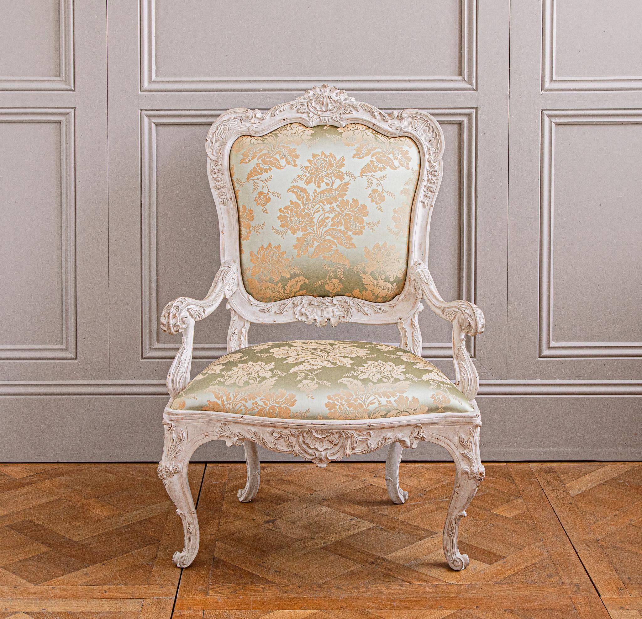 Re-edition of an 18th century Venetian armchair, hand-carved with beautifully crafted detailing. Hand finished in a gesso white patina, aged and distressed.
It has been reupholstered with a Classic Lelievre Damask.

