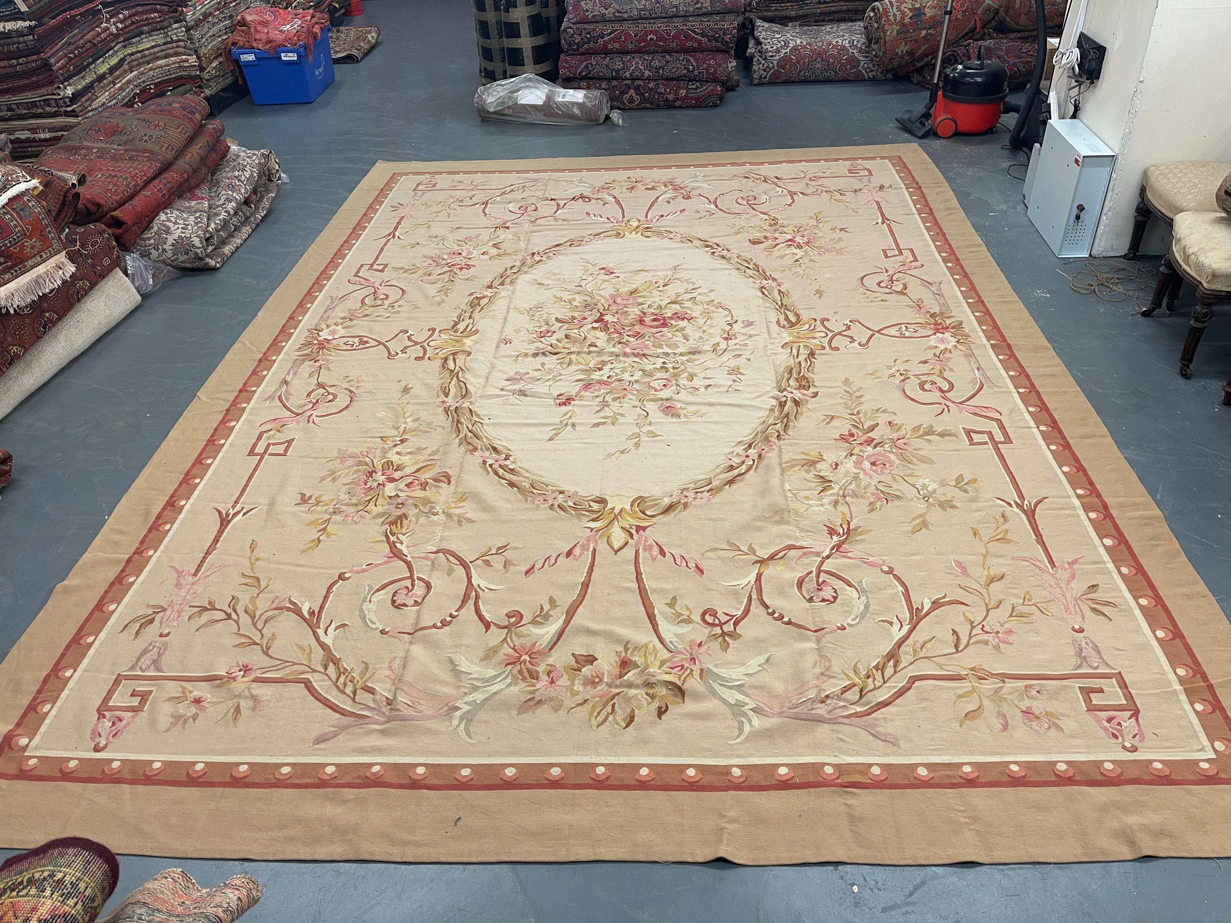 This fantastic area rug has been handwoven by Aubusson with a beautiful symmetrical floral design woven on a beige-pink background with accents of coffee, burgundy, and ivory. This elegant piece's colour and design make it the perfect accent