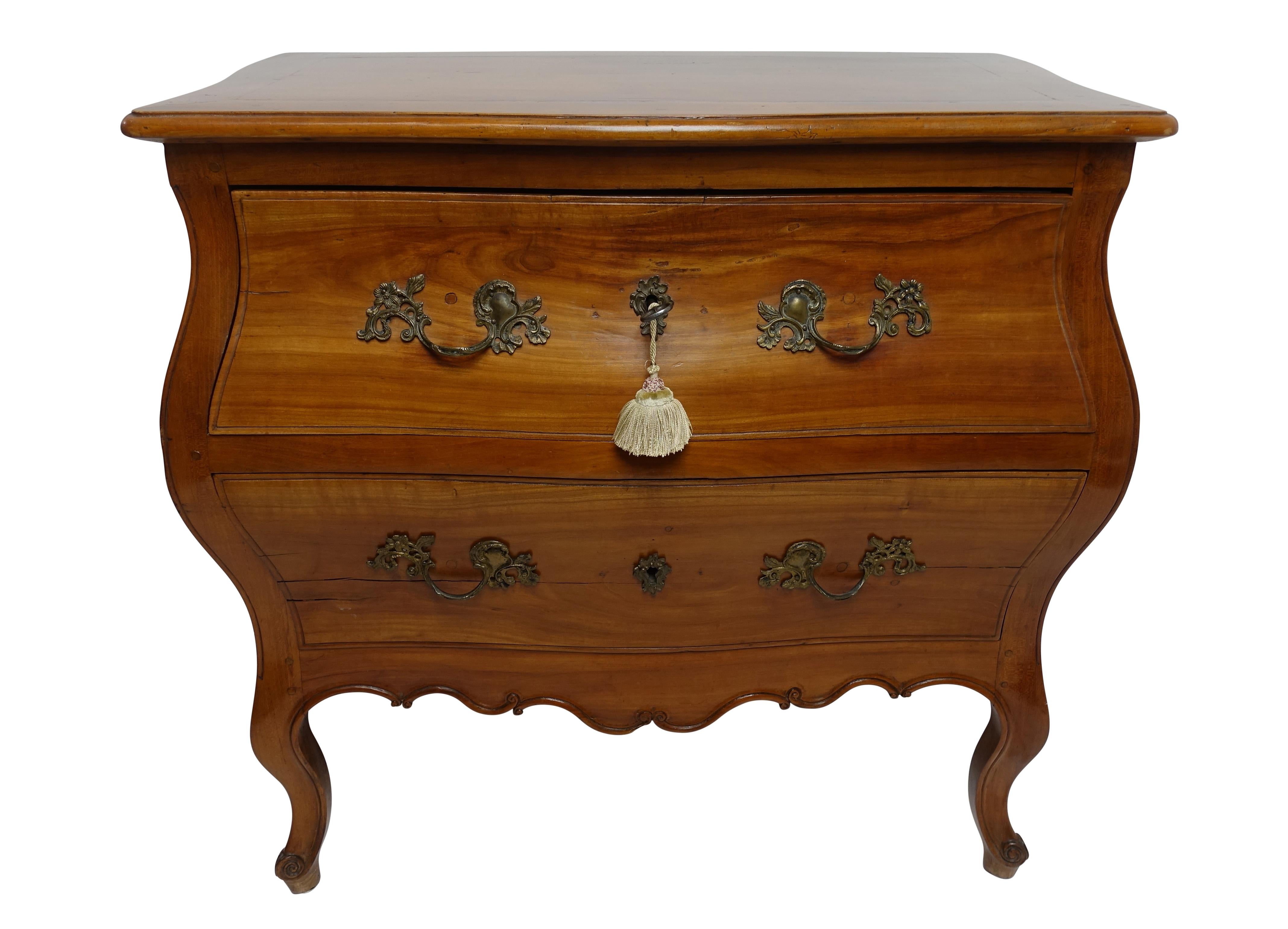 Exceptional cherrywood Bombe two-drawer commode chest of drawers. Serpentine shape top above two professionally fabric lined drawers with a pair of fancy scroll pulls flanking escutcheon with working lock and tasseled key the each side having raised