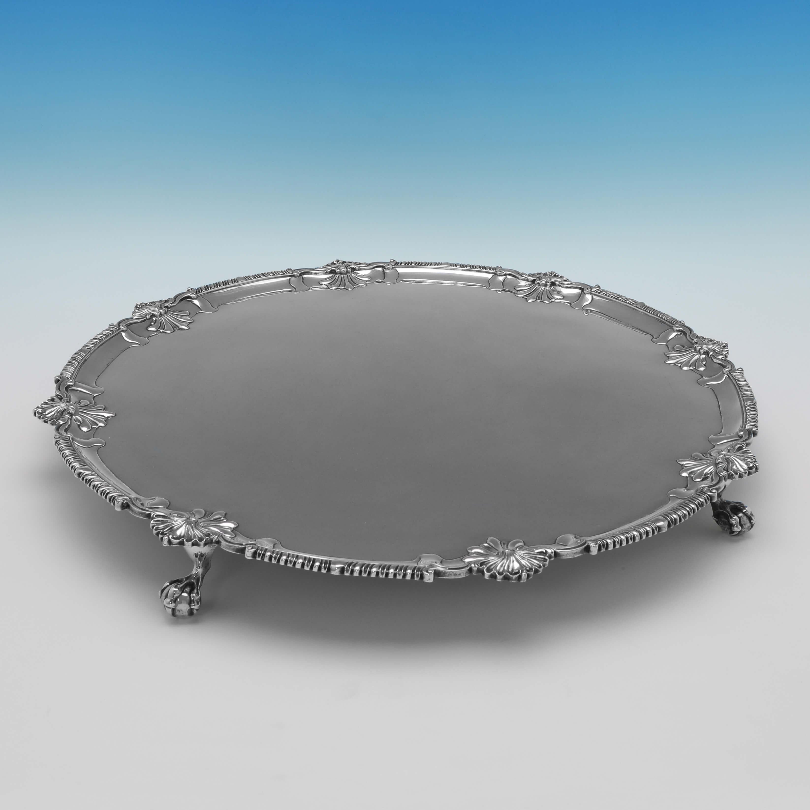 Hallmarked in London in 1772 by Richard Rugg, this wonderful, George III period, antique sterling silver salver, features a shaped shell and gadroon borders and stands on 4 lion paw feet. The salver measures 2