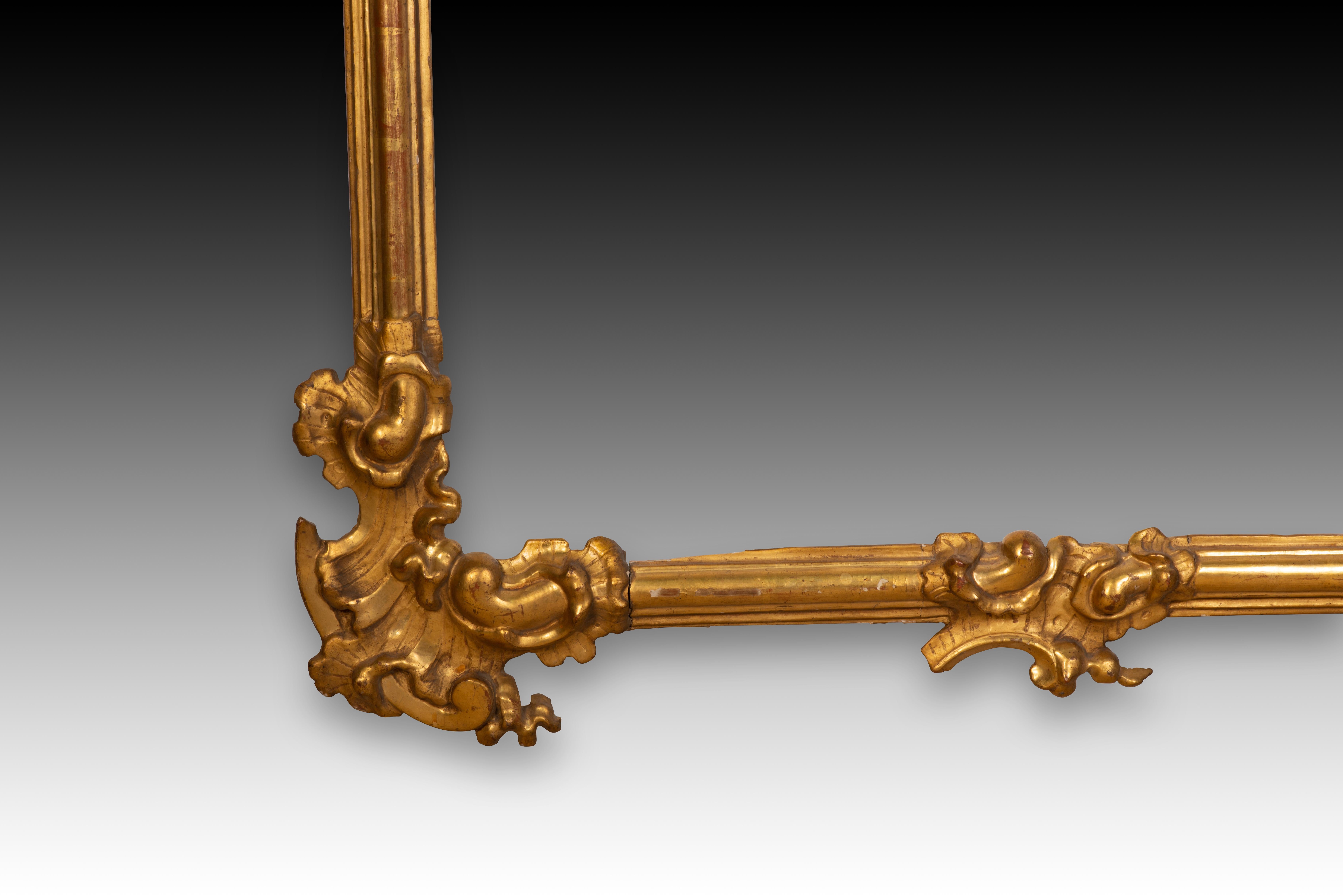 Rococo frame. Gilded wood. 18th century. 
Rectangular frame made of carved and gilded wood, and decorated in the corners and the centres of the sides with carvings of architectural elements, plants and rocaille. The contrast between the smooth