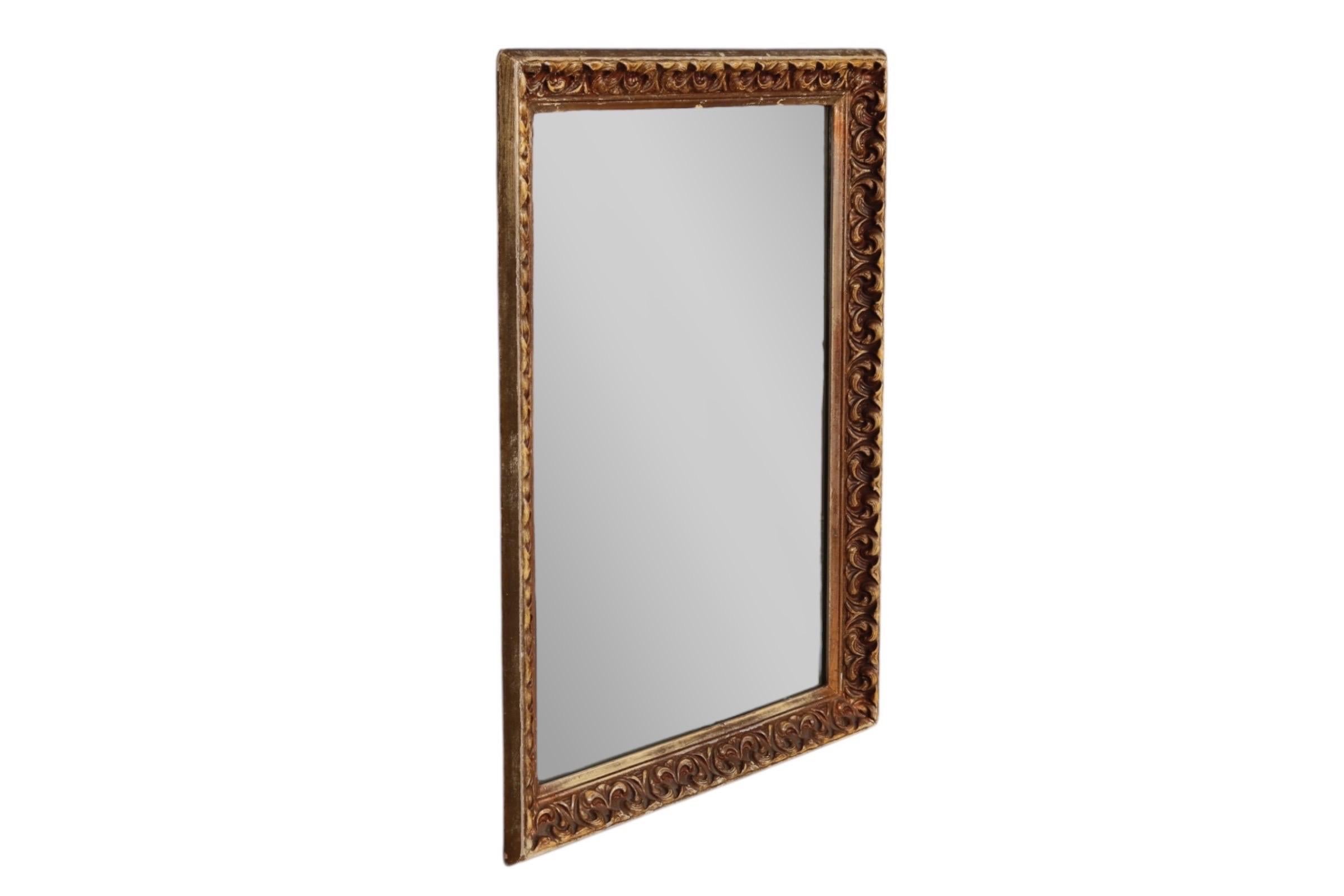 Miroir rectangulaire dans un cadre en bois et gesso décoré de rinceaux rococo dorés. Le câble peut être suspendu horizontalement ou verticalement.
