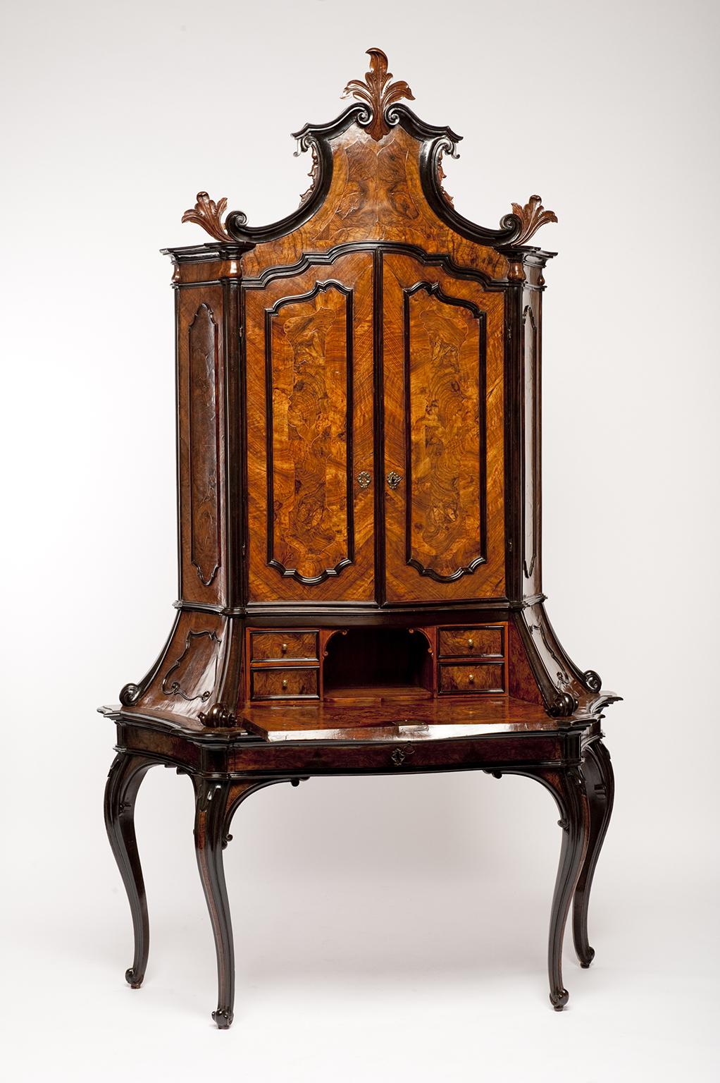Bureau-cabinet with fold-down writing desk
Lombardy, third quarter of the 18th century
Walnut with carved decoration and walnut-burl veneer; applied ebonized wood trim and cornice
It measures 104 x 60.6 x 22.4 in (264 x 154 x 57 cm)
State of