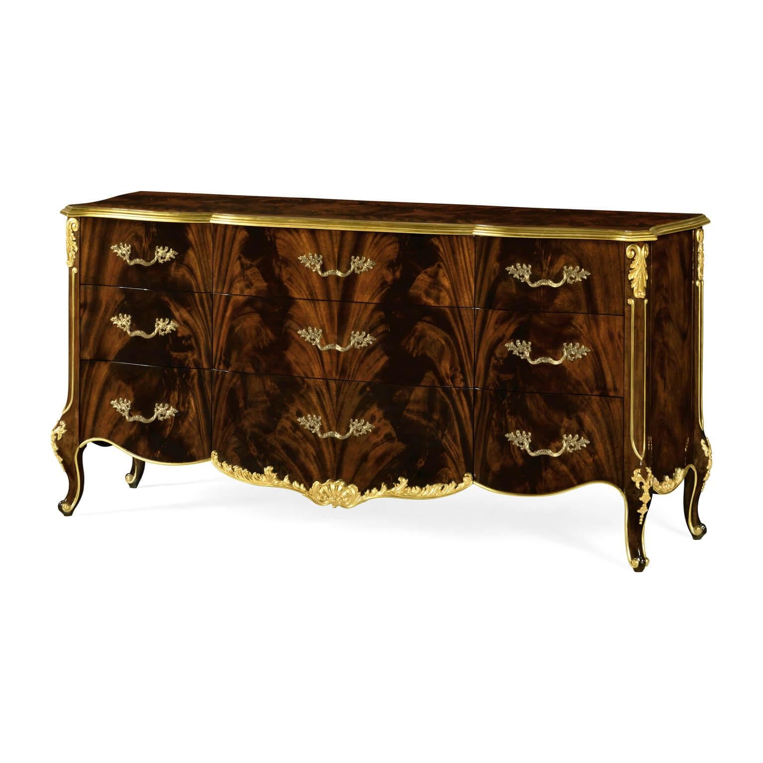 A large Rococo style mahogany and gilt carved nine-drawer dresser with serpentine shape and bronze handles.

Dimensions: 72