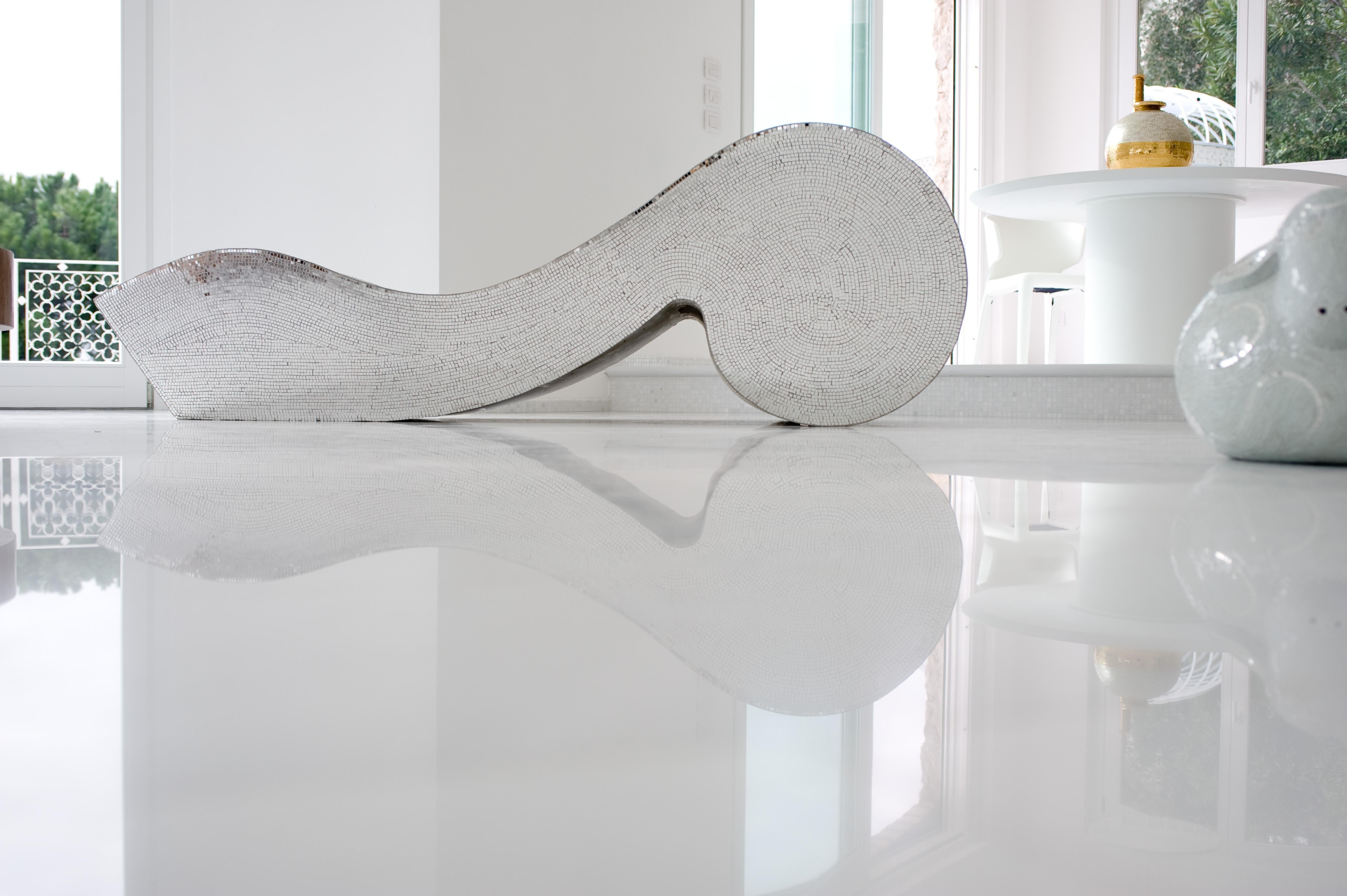 A show-stopper sure to catalyze attention in any indoor or outdoor context, this glamorous piece can simultaneously be a chaise-longue or a glistening mosaic sculpture. Its sinuous core in polyethylene is fully covered with square mirrored glass