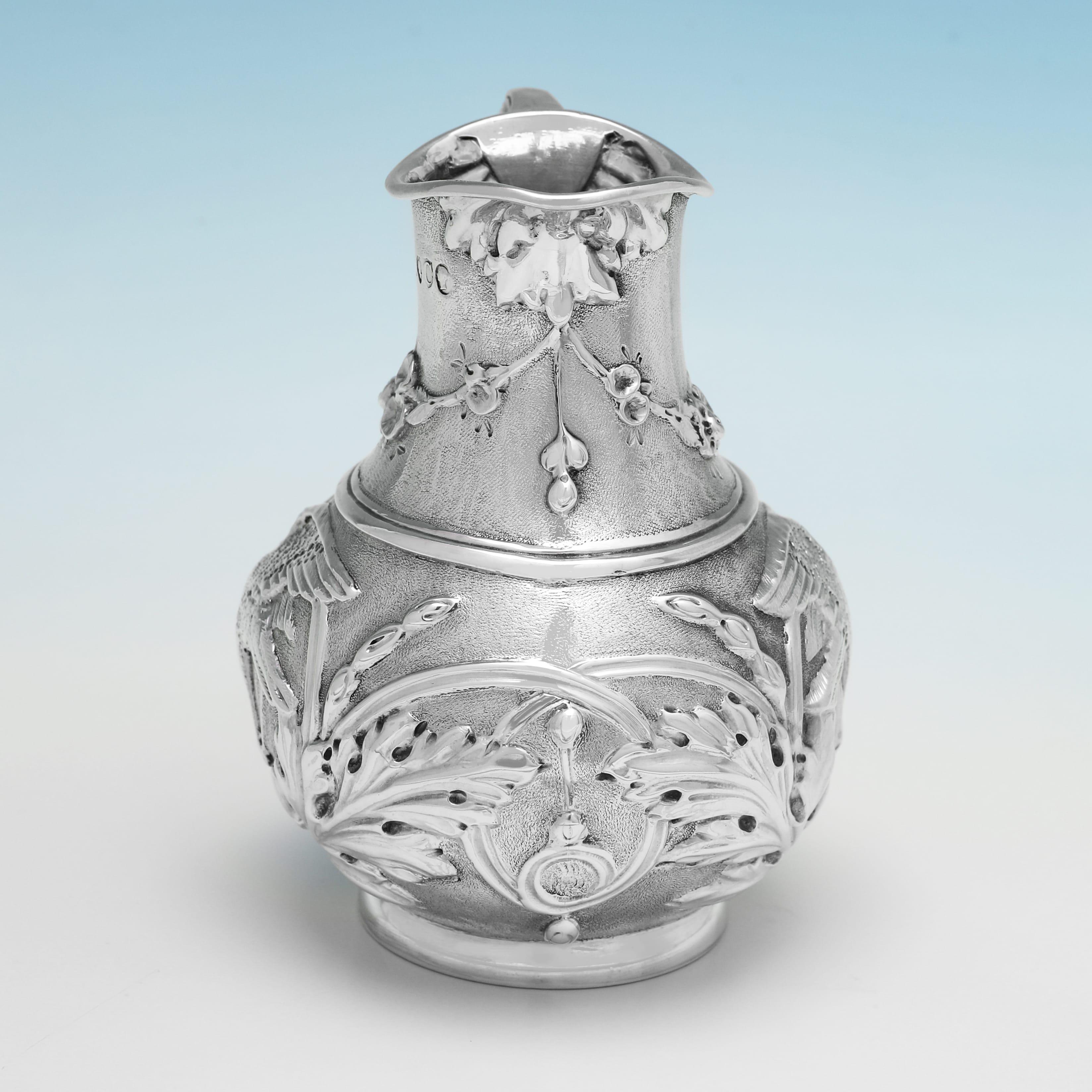 Marcada en Londres en 1878 por Henry Wilkinson & Co., esta atractiva jarra victoriana de plata de ley para crema presenta una maravillosa decoración cincelada. La jarra de crema mide 9 cm de alto, 6,5 cm desde el asa hasta el pitorro, 7 cm de fondo