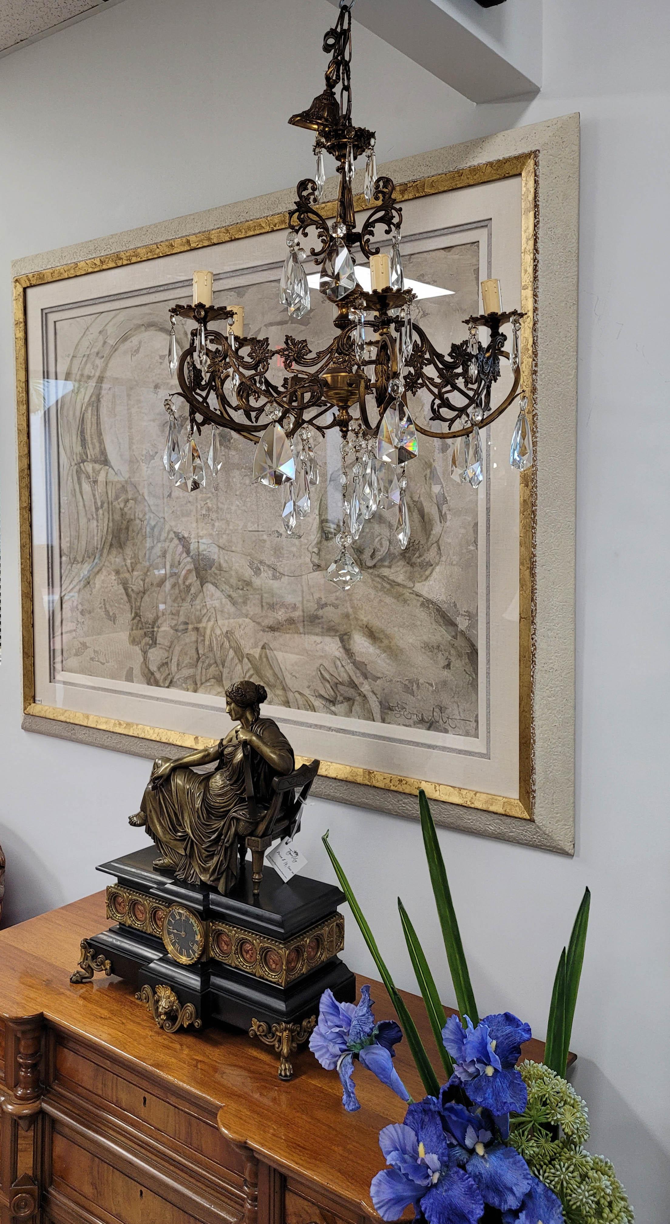 Questo elegante lampadario Rococo Revival di medie dimensioni, risalente alla fine del XIX e all'inizio del XX secolo, mette in mostra il fascino ornato del design di ispirazione francese. Realizzata in bronzo, la cornice è caratterizzata da cinque