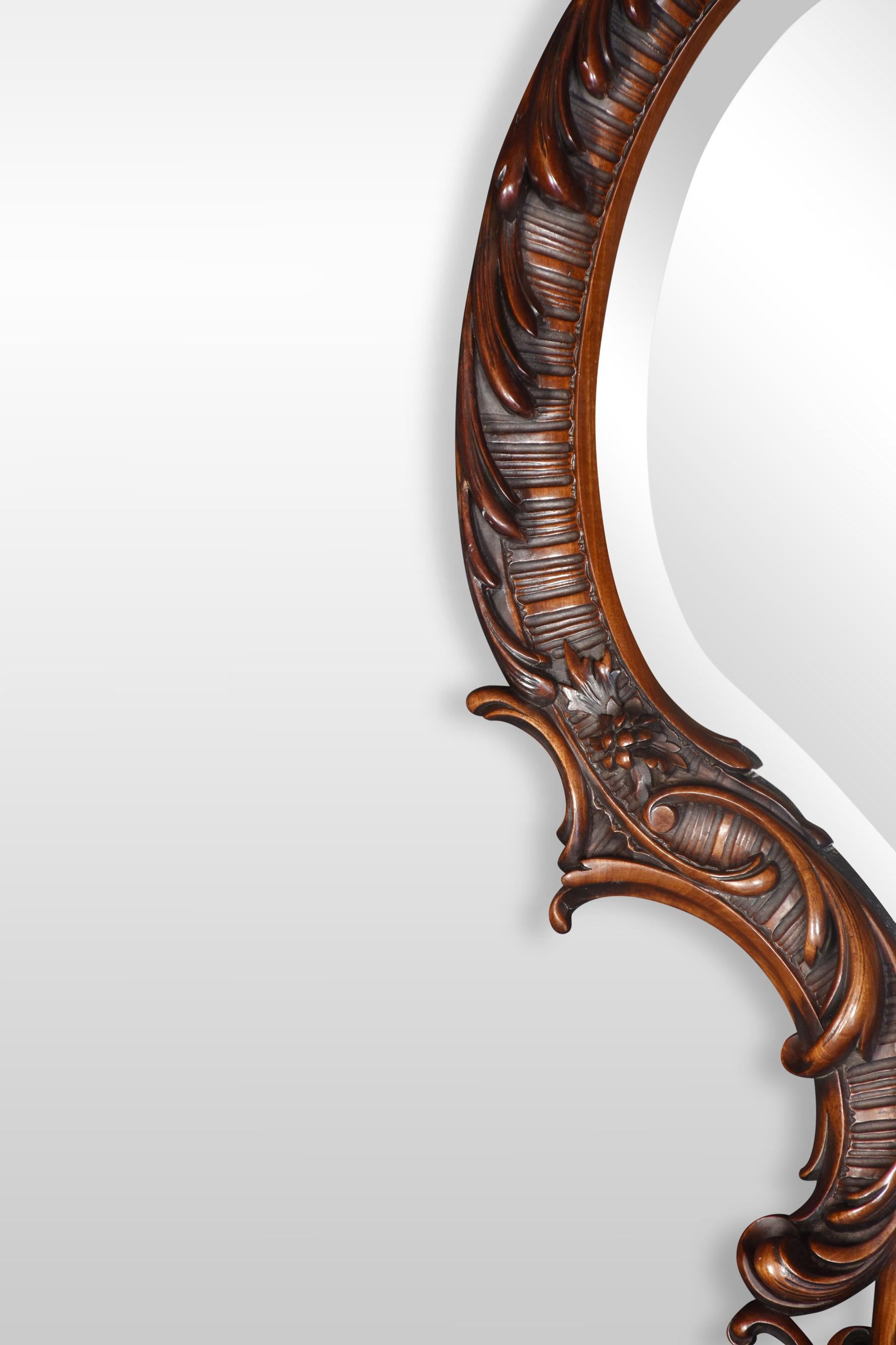 19th century rococo revival mahogany wall mirror, the asymmetrical shape with a beveled glass plate, heavily carved with rocaille scrolls and foliate details.
Dimensions
Height 49 inches
Width 23 inches
Depth 6.5 inches.