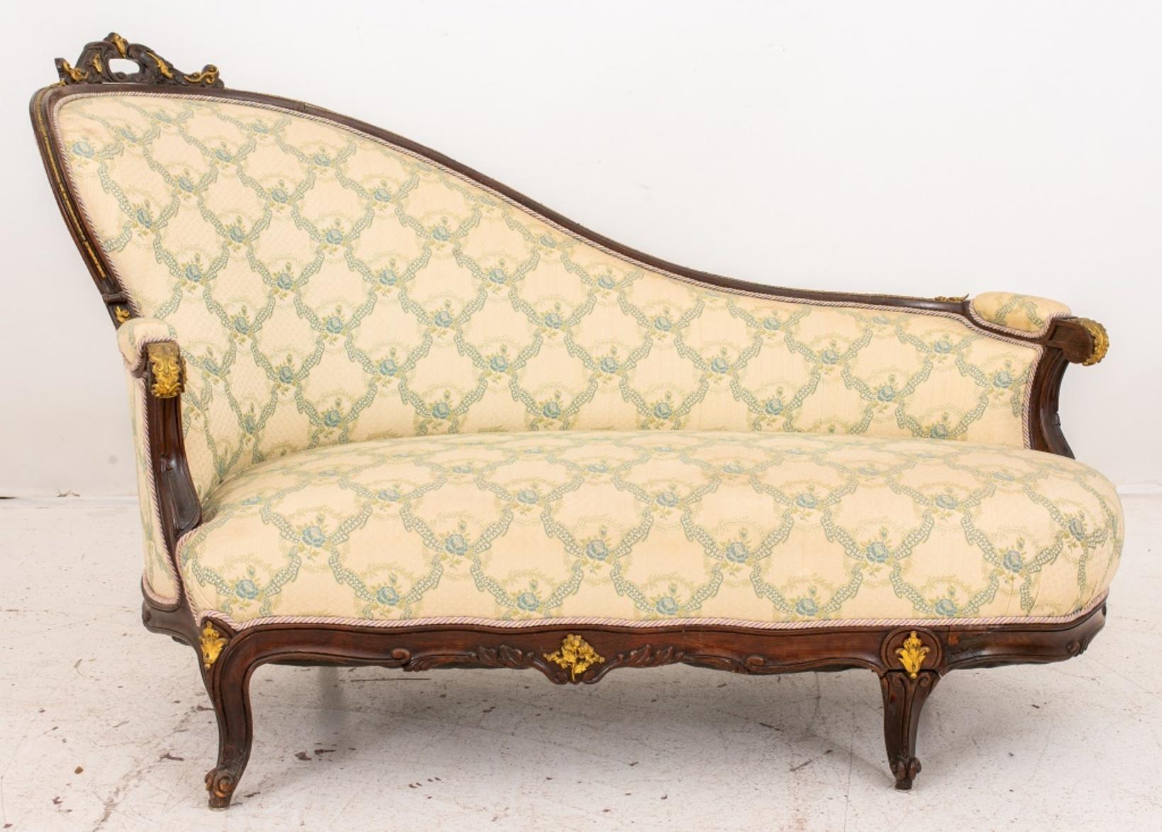 Rococo Revival ormolu mounted rosewood sofa in the form of a chaise, the crest rail with ormolu mounted carved rocaille above a down swept upholstered back, and arms above a shaped seat rail, upholstered in a blue and white damask on cabriole legs