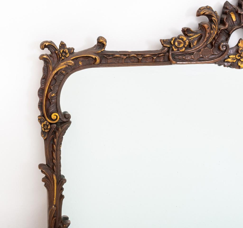 Rococo Revival parcel gilded mirror with reticulated rocaille crested cornice above scrolling and molded frame, centering a horizontal mirror plate.