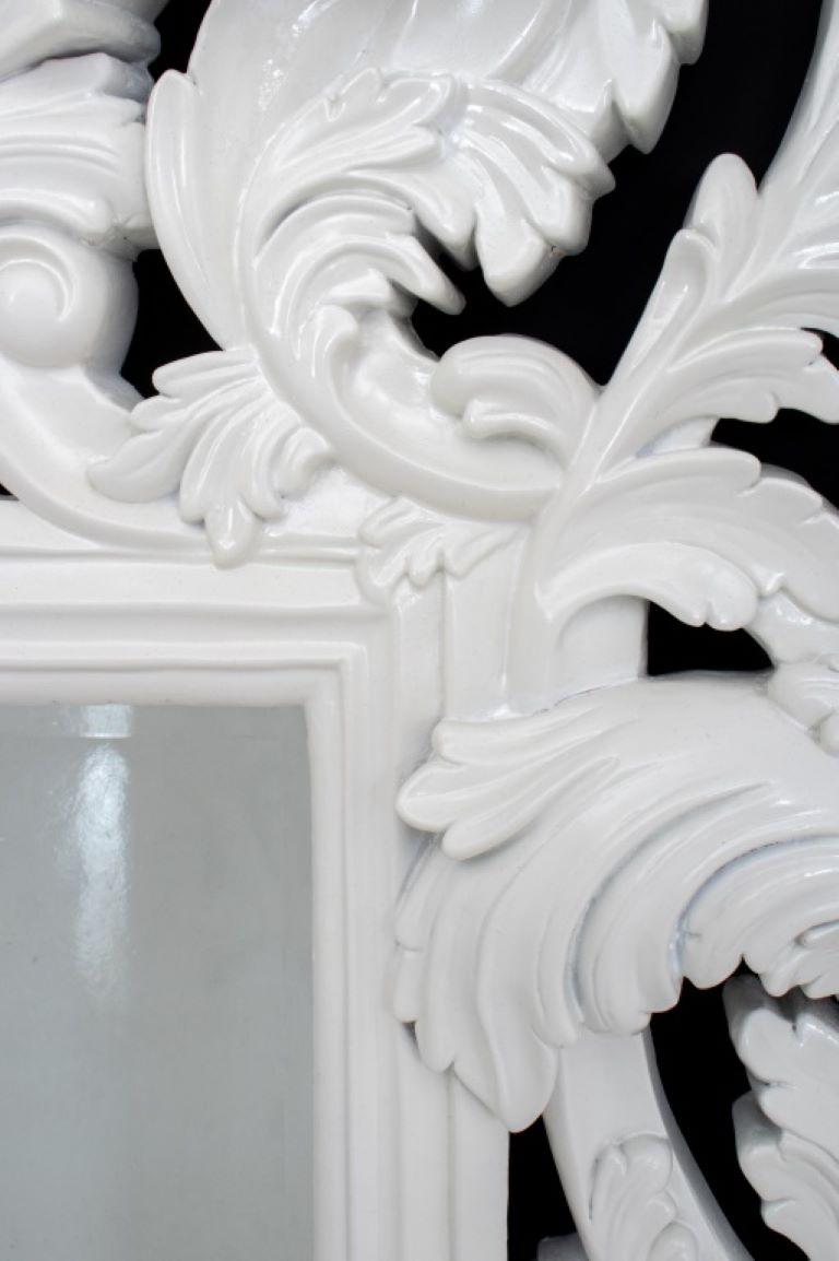 Rococo revival large white lacquered composite wall mirror with beveled glass surrounded by carved acanthus leaves motifs .

Dealer: S138XX