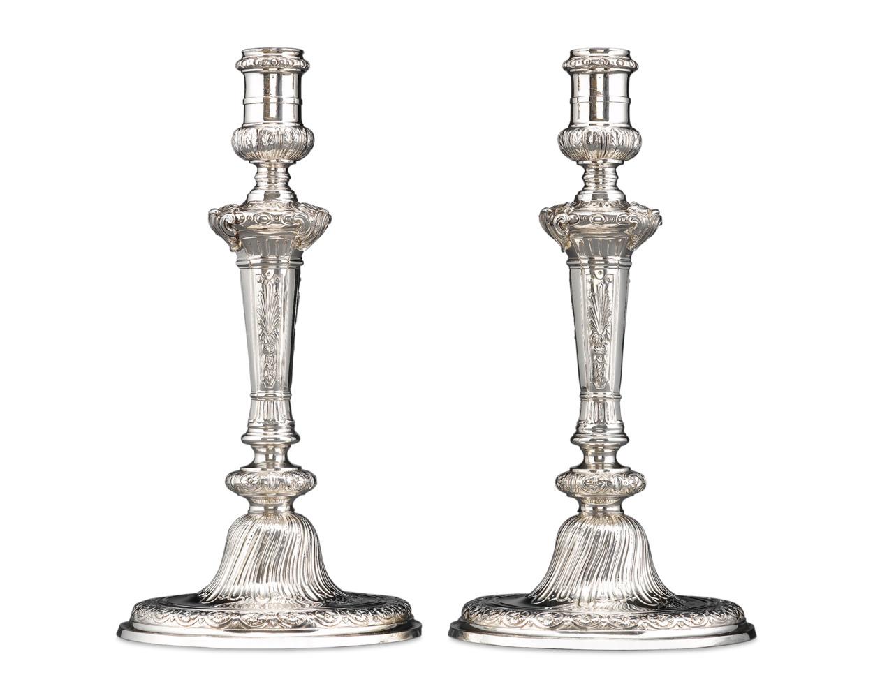 Un'eccezionale coppia di candelieri in argento sterling dell'argentiere inglese Alexander Johnston. Riflettendo il gusto georgiano della metà del XVIII secolo per lo stile rococò, questi candelieri presentano decorazioni profondamente cesellate, da