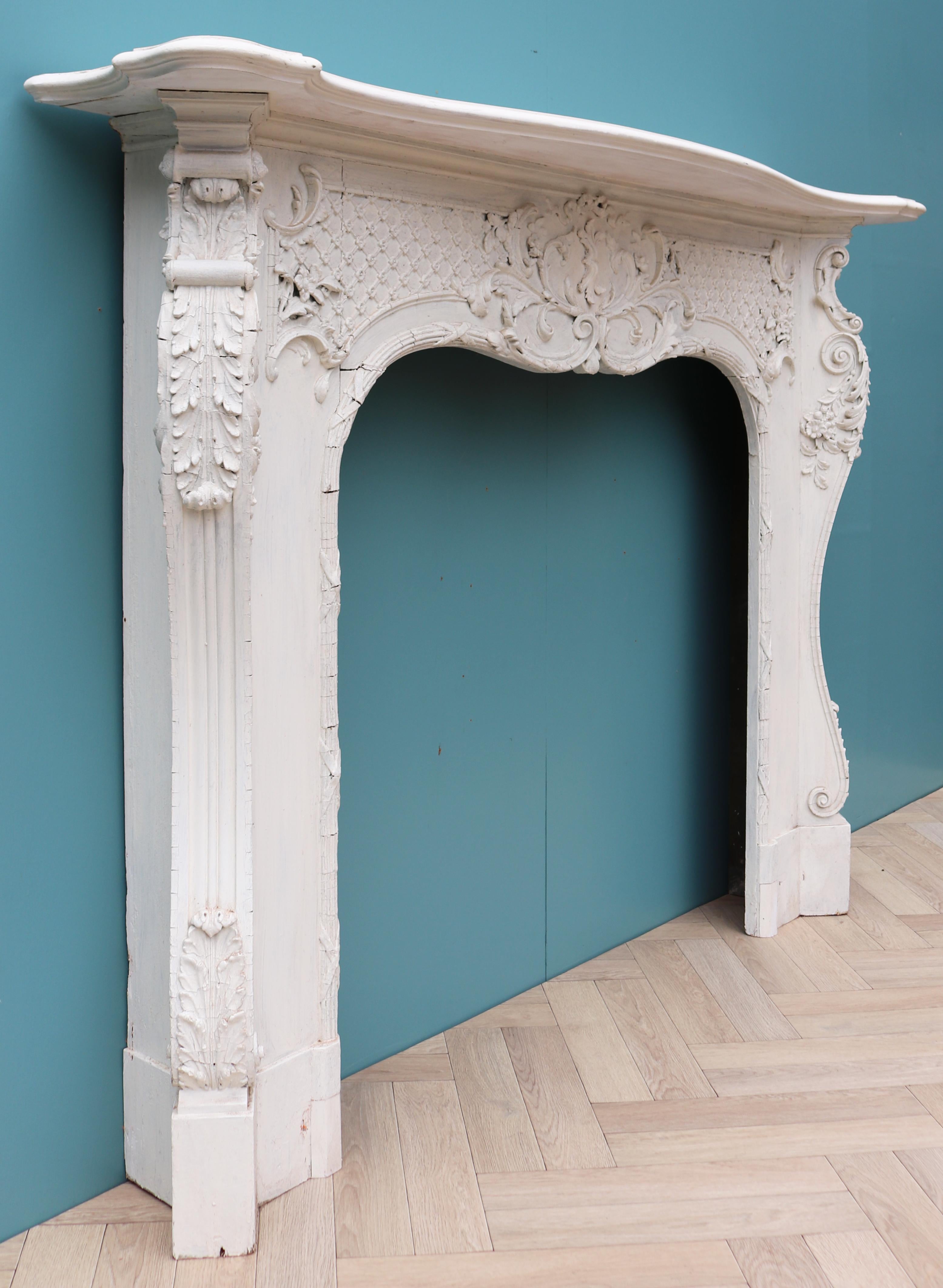 An English Rococo style fire surround reclaimed from a large house in Little Venice, London.

Additional Dimensions:

Opening Height 104 cm

Opening Width 107 cm

Width between outside of foot blocks 165 cm