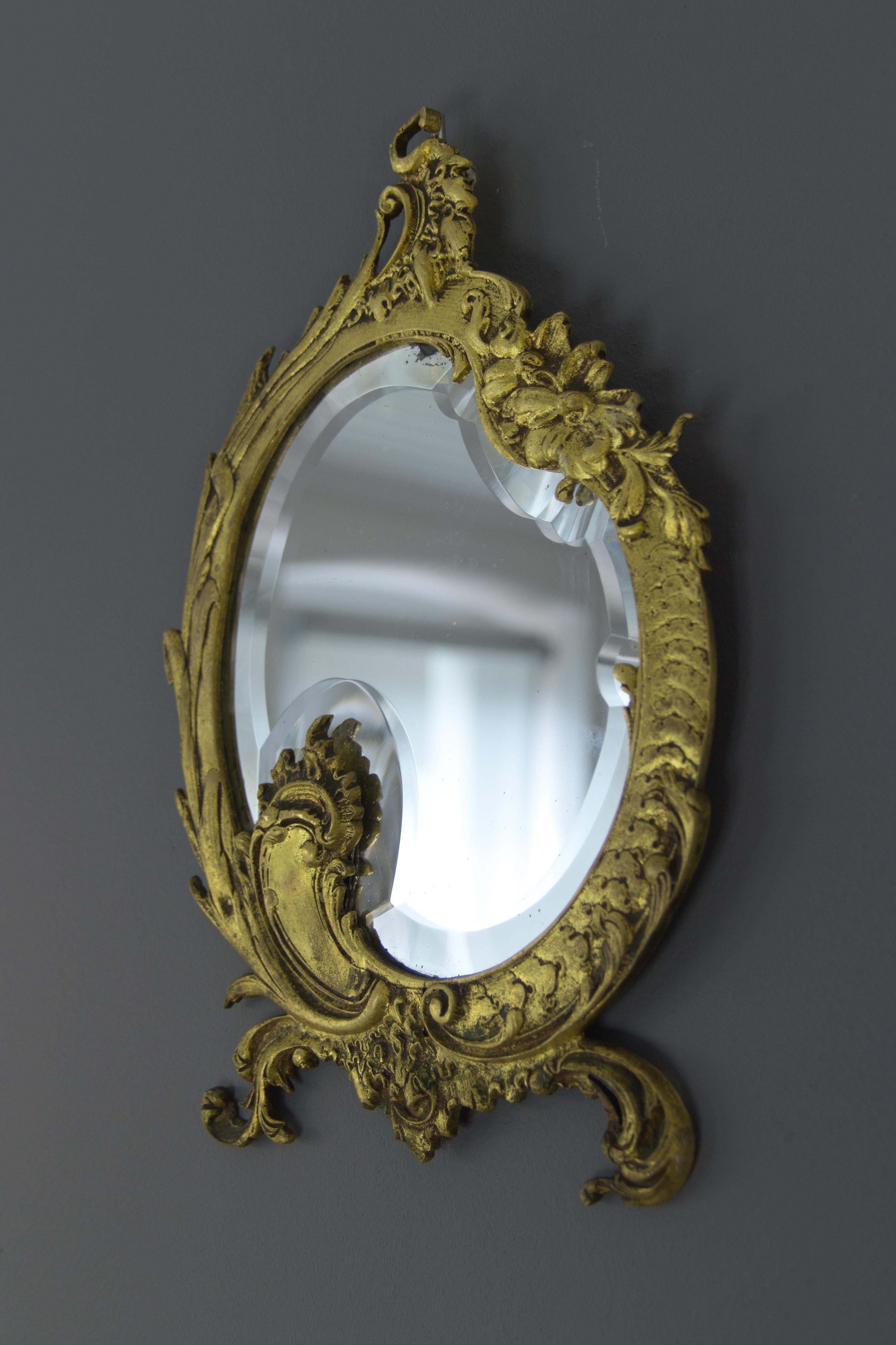 Adorable Rococo style French bronze wall mirror decorated with floral, leaves and scroll details, beautifully shaped beveled mirror.
Dimensions: height: 32 cm / 12.59 in; width: 21 cm / 8.26 in; depth: 2 cm / 0.78 in.
  