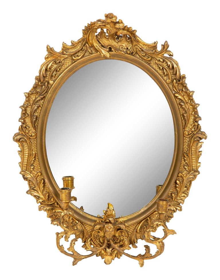 Rococo-style carved giltwood girandole mirror, 19th century. Measures: height 31 1/2 x width 23 inches.
 