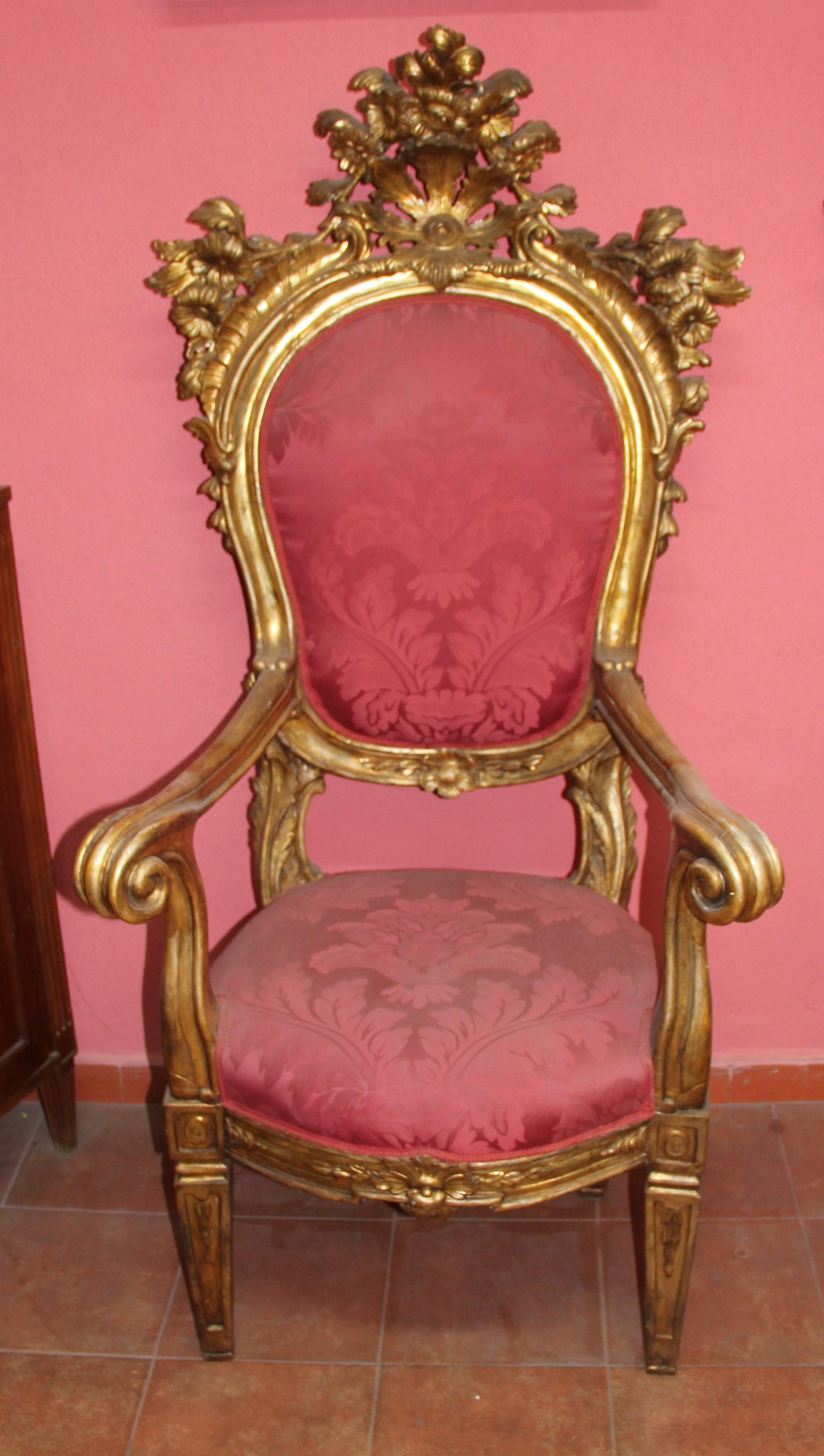 With an ornate flower-head and flowering vase cresting above an arched oval form padded back with open scroll arms, the bowed seat raised on square tapered legs.
The Throne is executed in the Rococo style, an ornate asymmetrical style using
