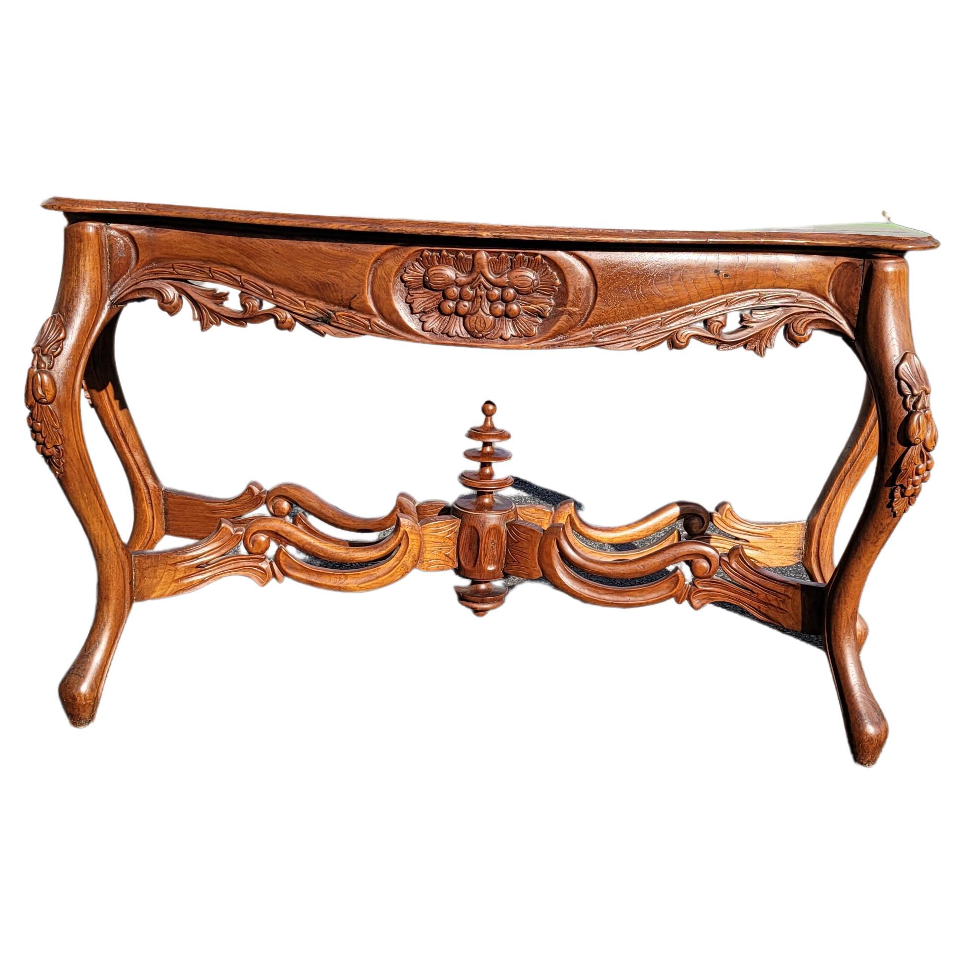 A French Rococo Style Carved Mahogany Serpentine Console Table with beautiful carvings of fruit , leaves and branches with beautiful carved stretcher center topped by a carved crown underneath in Very good vintage condition.  Measures 55