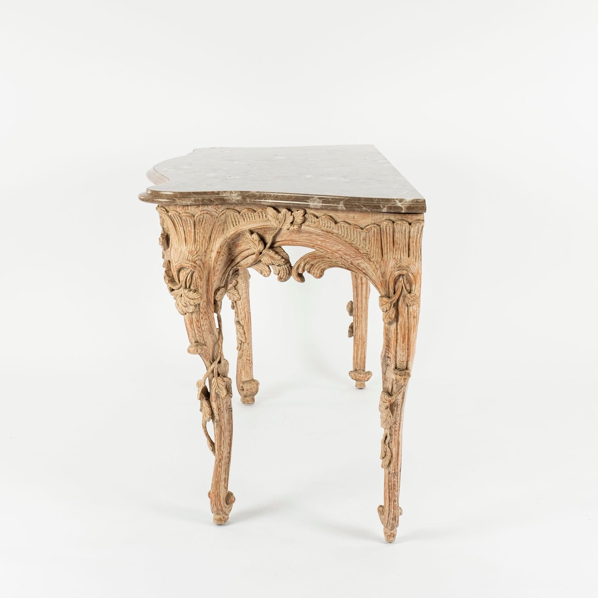 20th century hand craved bleached wood Rococo style console with brown marble top. Lovely shell cartouche, oak foliage and scroll work detail.