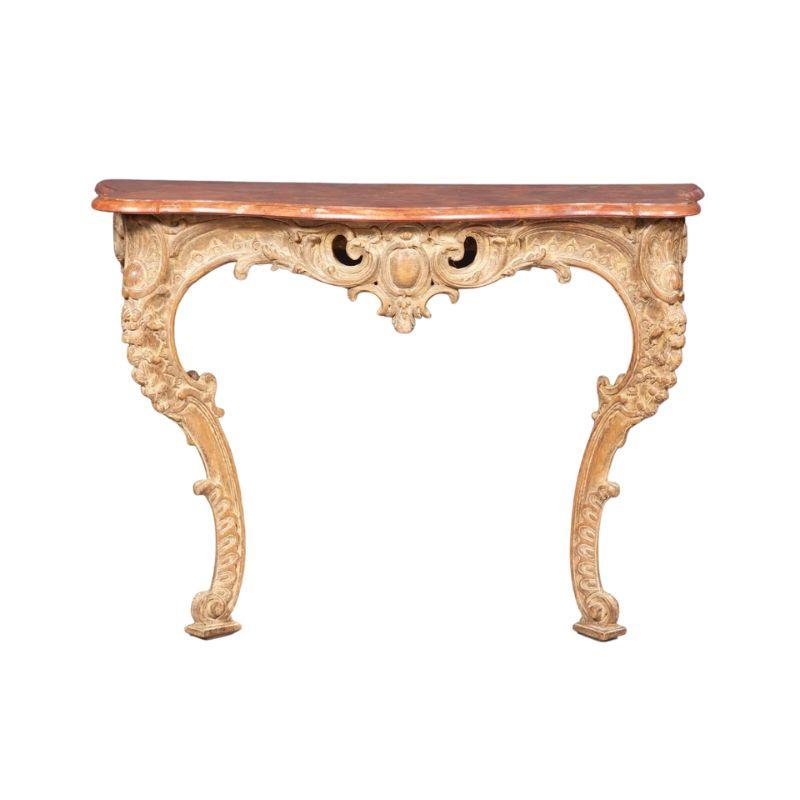 A Louis XV style carved wood wall mount console table with a painted faux marble top. The rococo console base is painted and intricately carved on three sides with many curved swags and details. The cabriole legs are bowed at top and and end in a