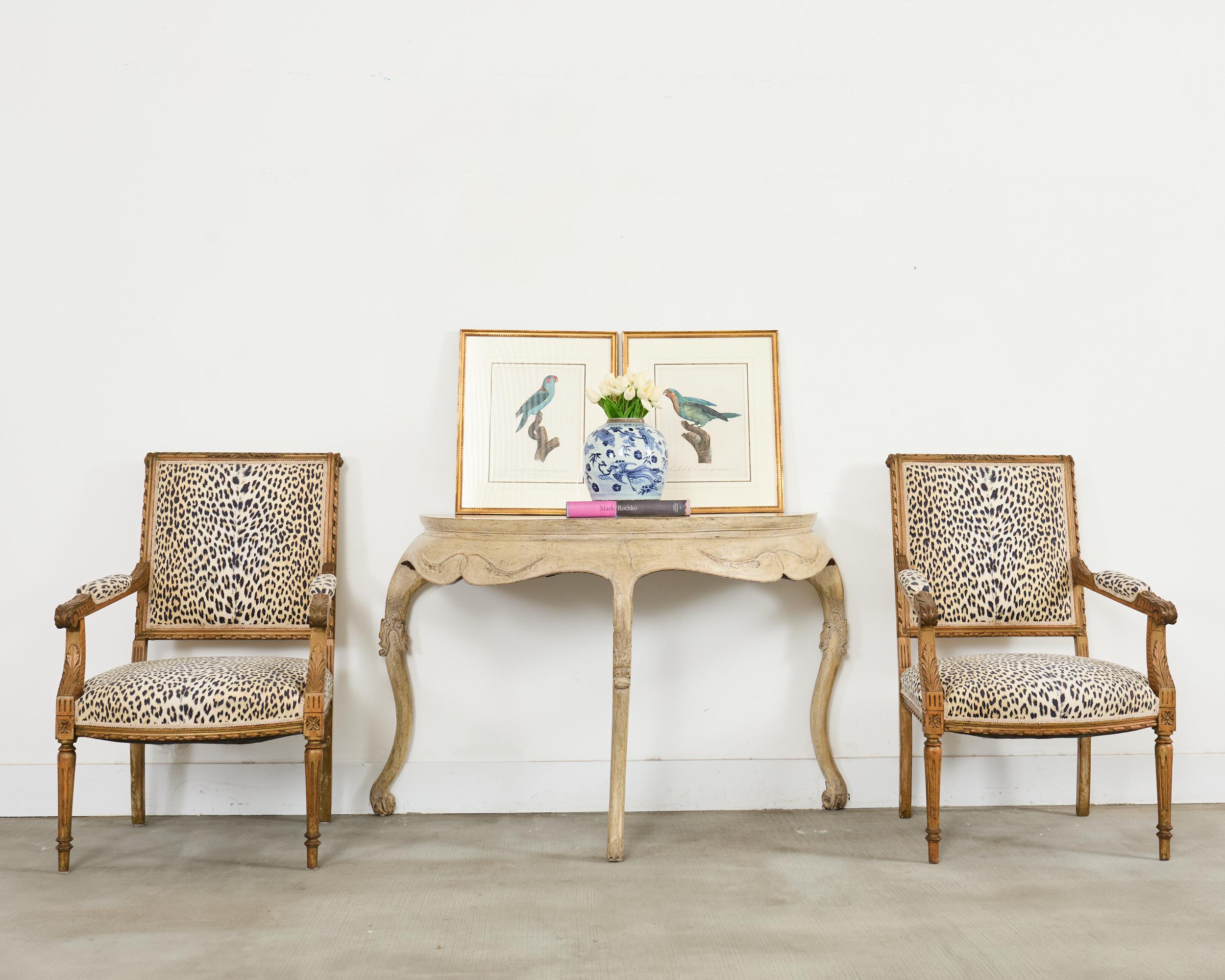 20th century weathered demilune console table or sofa table featuring an intentionally distressed faux painted finish crafted from hardwood with gracefully scalloped aprons and supported by curved cabriole style legs. The table is sturdy and solid