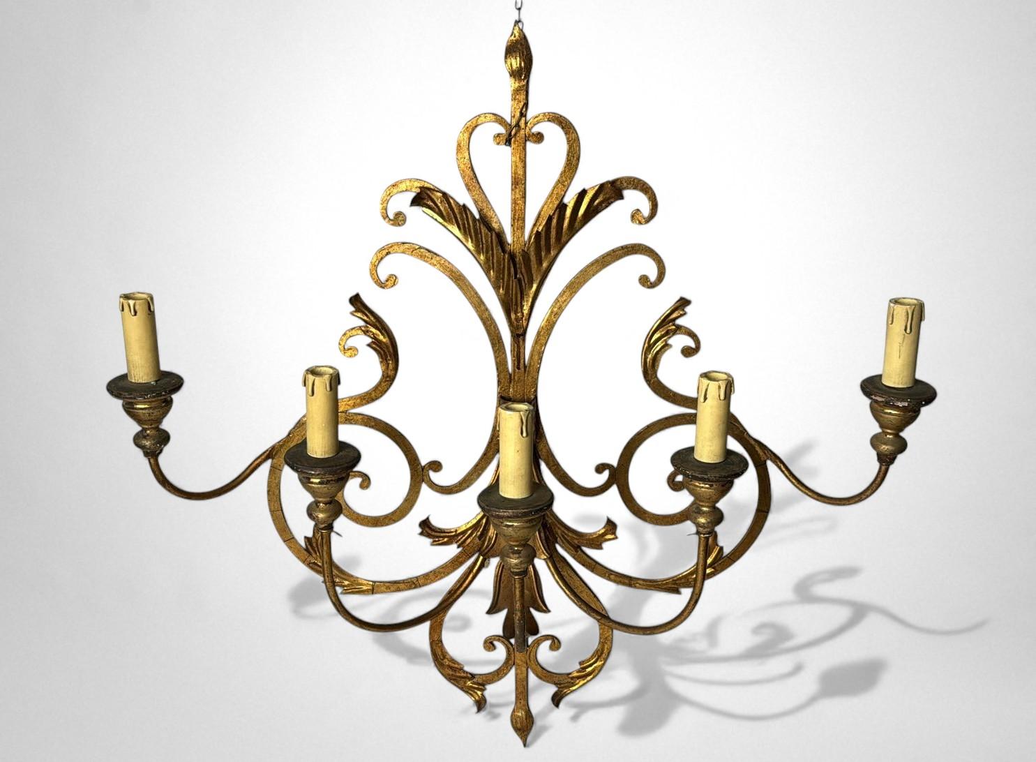 Impressionnante et élégante applique murale italienne à cinq lumières, dotée de fausses bougies et de bobèches en bois. Toute la structure, solide et bien proportionnée, est réalisée en fer forgé avec divers détails forgés à la main. Le design suit