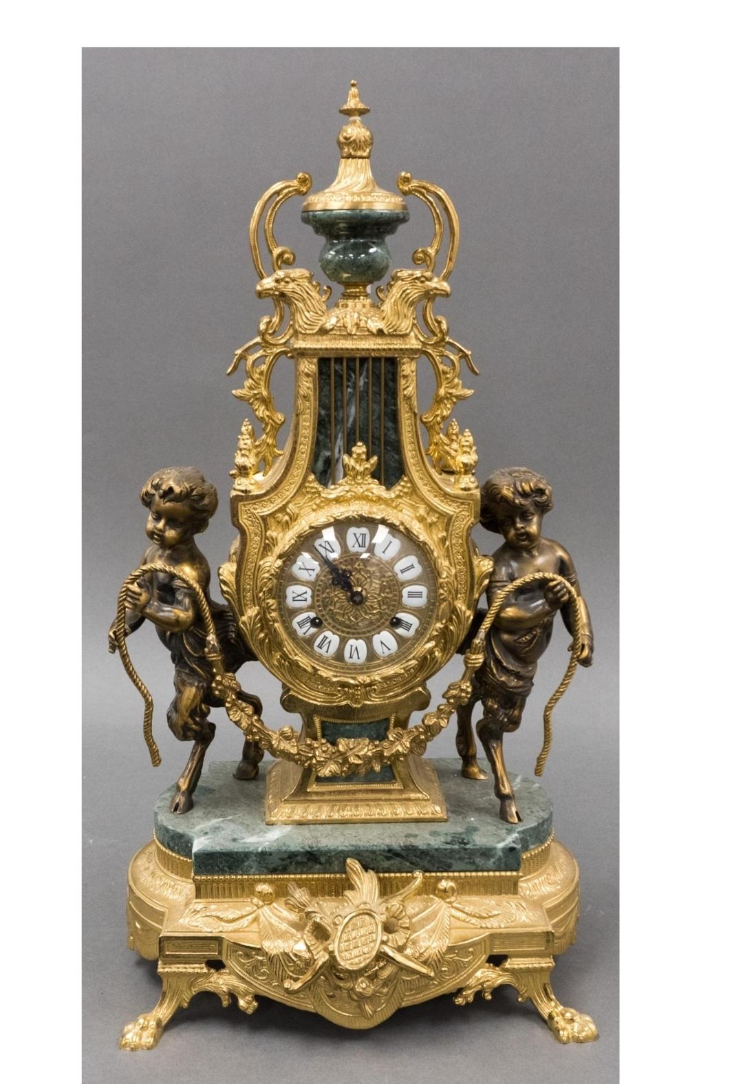 A clean Rococo-style gilt bronze figural mantel clock. The clock is a late 19th-century piece, featuring cherubs / satyrs. 
The style is characterized by elaborate scrollwork, foliage designs, and mythological figures. These clocks were popular in
