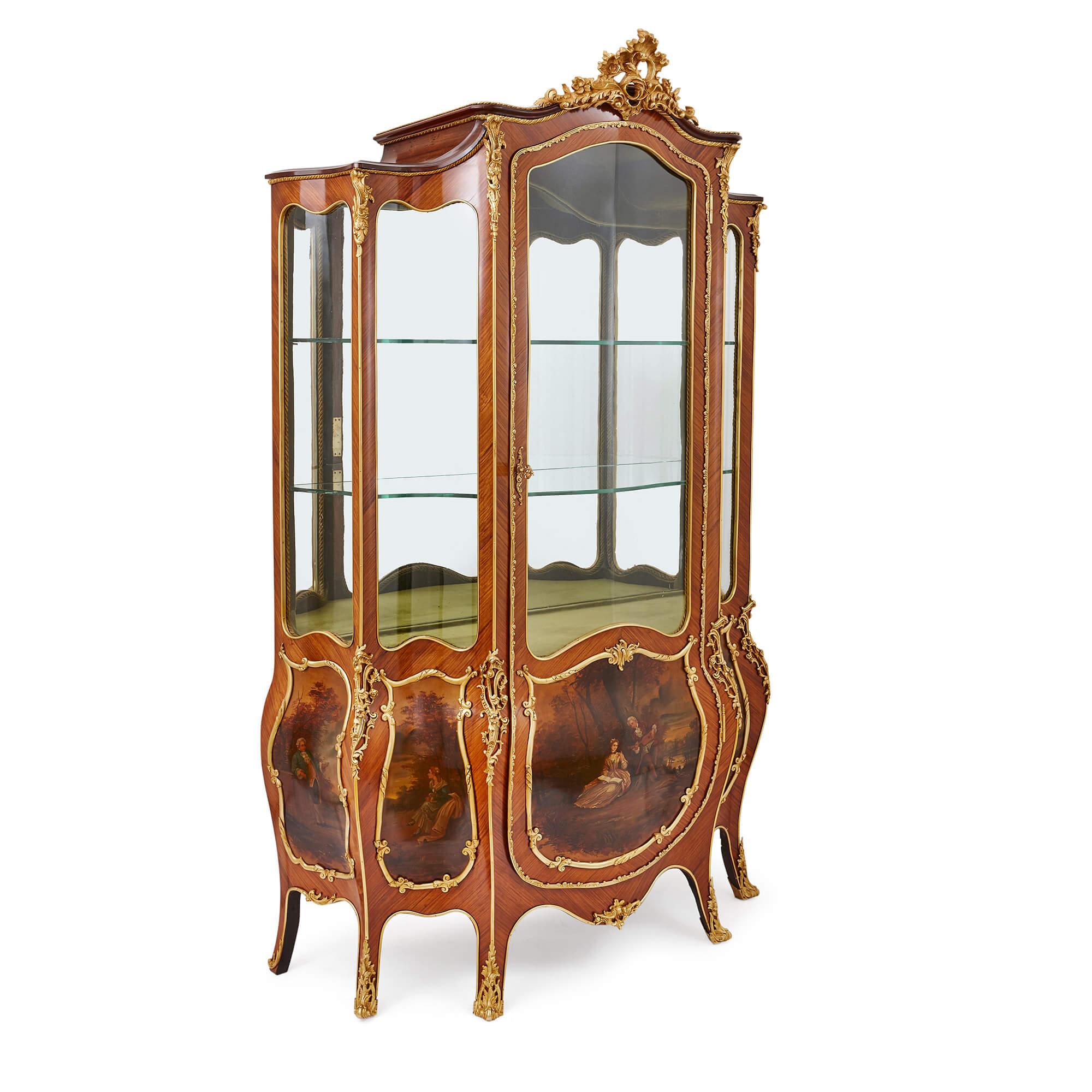 This large and exquisite vitrine cabinet is a true statement piece and would make the perfect place to display an antique collection of curios or fine tableware. 

The cabinet is crafted in kingwood, in a bombe form, and features a large central