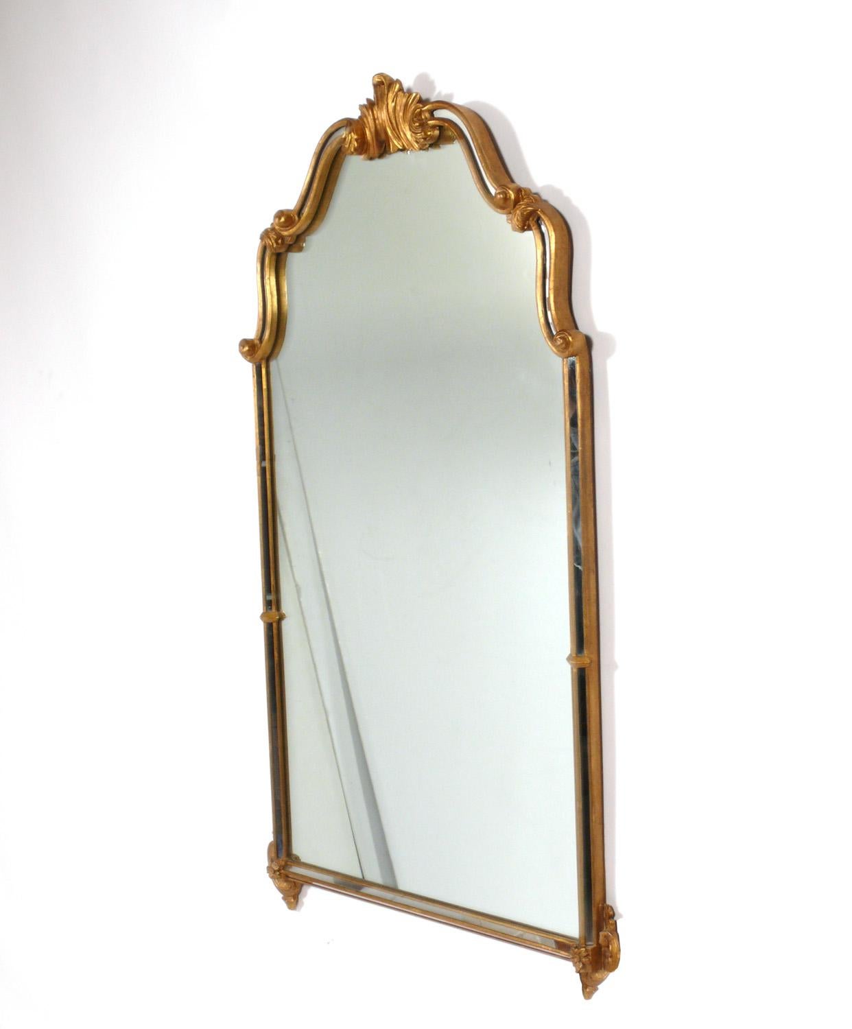Rococo style gilt mirror, probably American, circa 1960s. Elegant form retaining warm original patina to the gilt wood frame. It measures an impressive 49.5