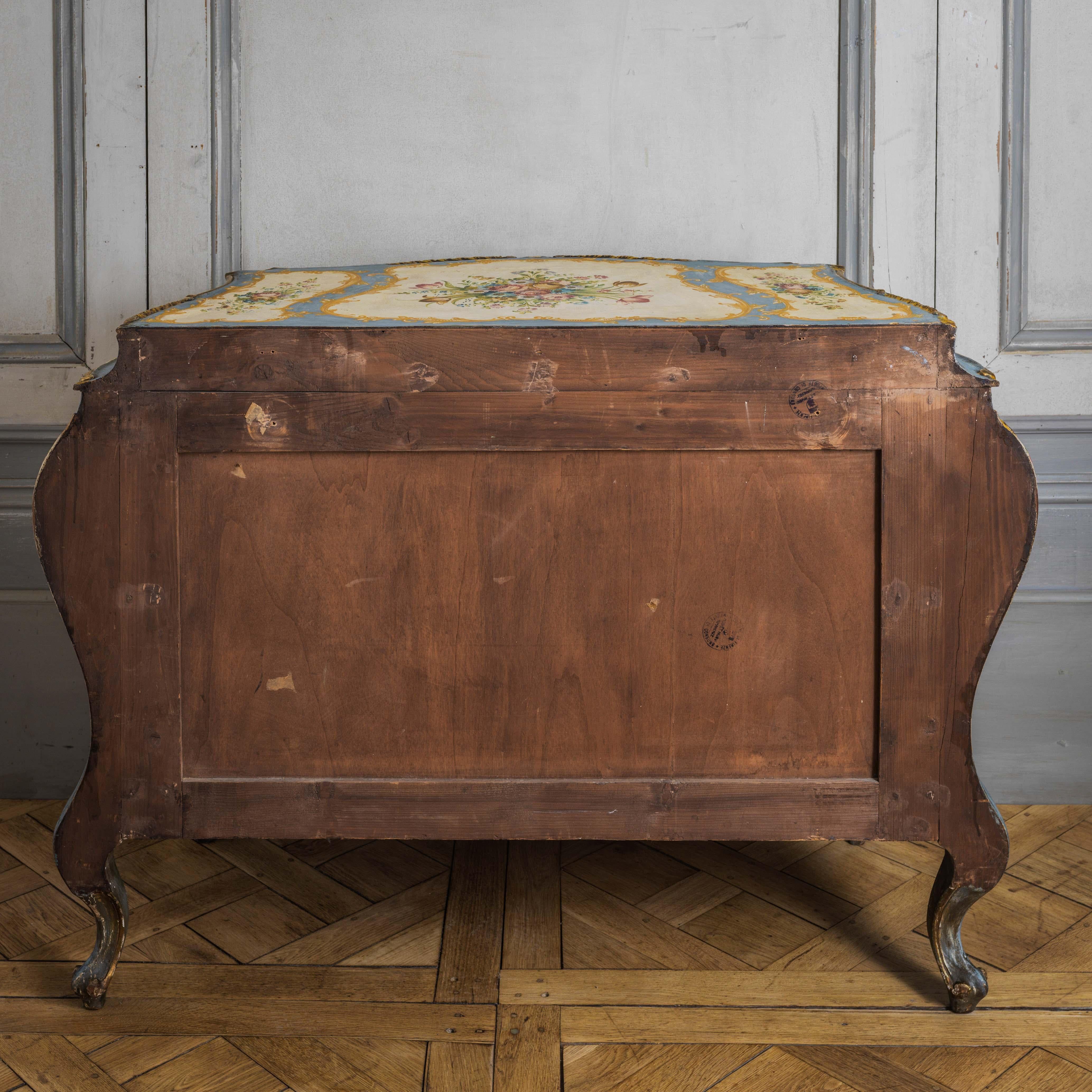 A vivacious Rococo style Tuscanian(Florence) bombe chest from the early 1900's, hand painted with delicate floral motifs on the main colours of old white and cobalt blue with gilded highlights.