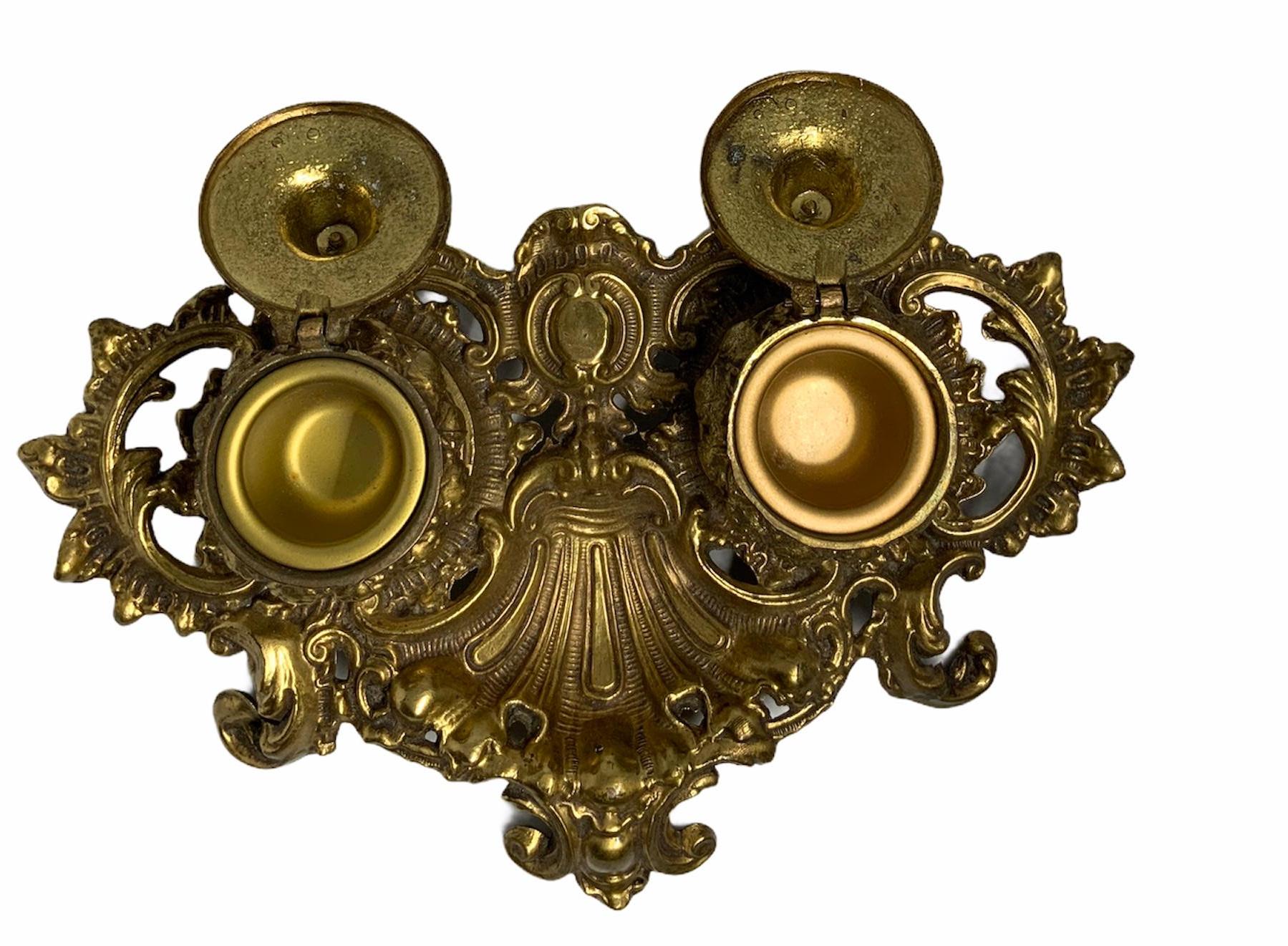 Embossing & chasing techniques are highlighted in the Rococo motifs of this gilt bronze inkwell. The inkwells are shaped as garlic domes. The exaggerated rocaille shaped tray with large scrolls serve as the base for the beautiful well worked hinged