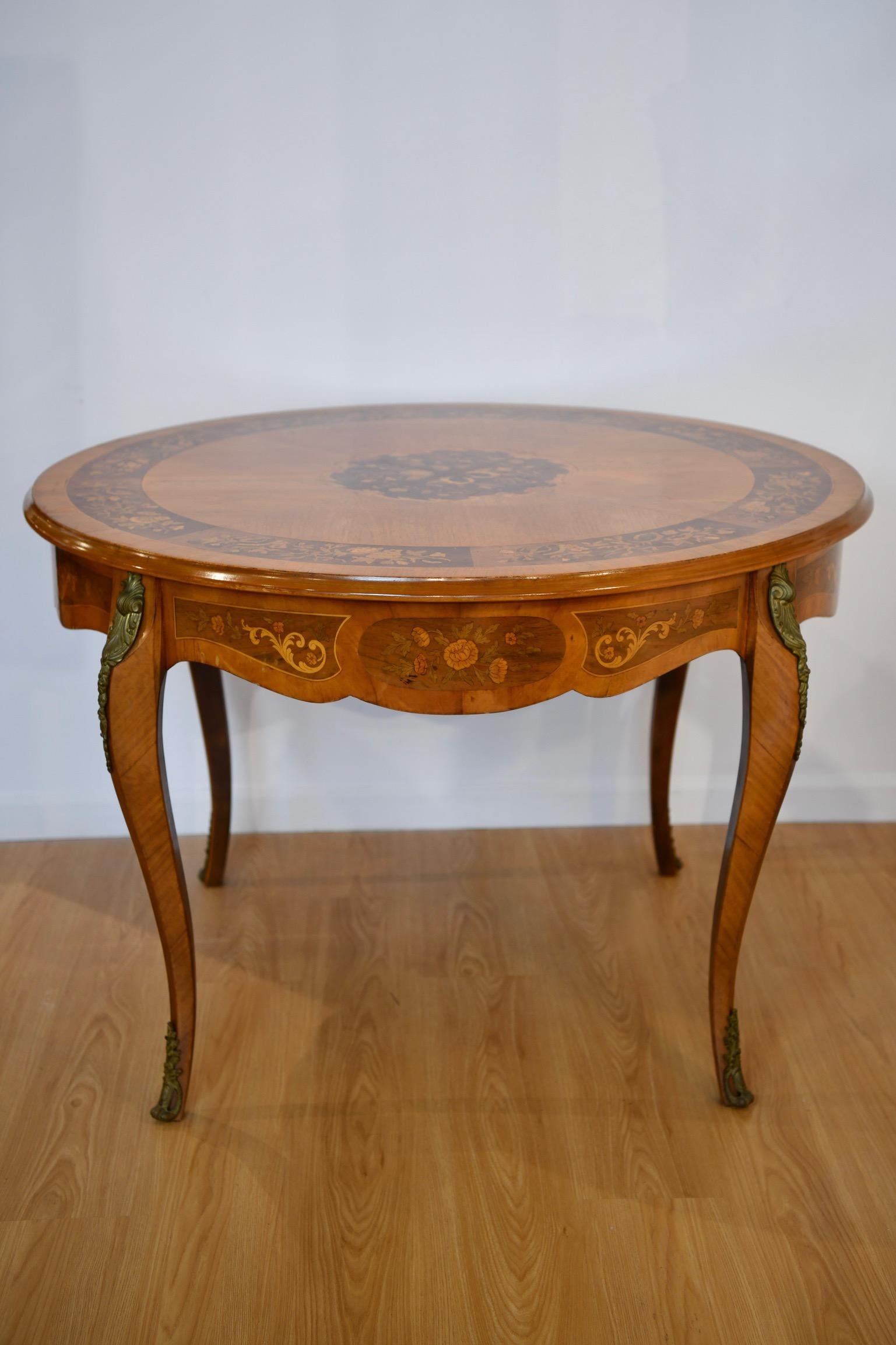 Rococo-style inlaid dining table with marquetry inlaid frieze panels between gilt metal mounted cabriole legs. In very good vintage condition. Dimensions: 31
