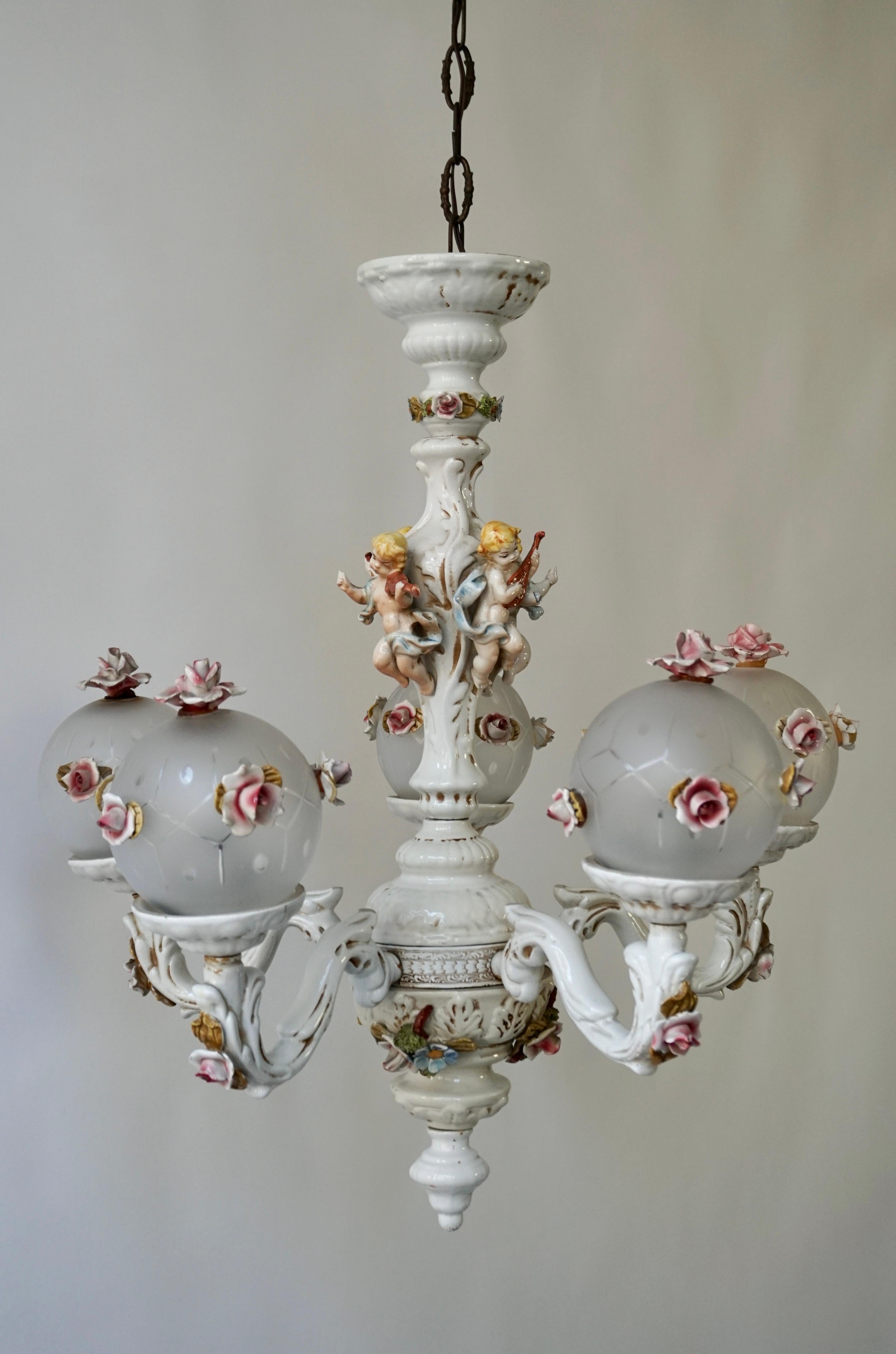 Gorgeous Italian porcelain chandelier with exquisite floral arrangements and five glass globes.

This magnificent chandelier is an exceptional example of the Rococo style.The chandelier features a shaped baluster-form stem and adorned with flowers