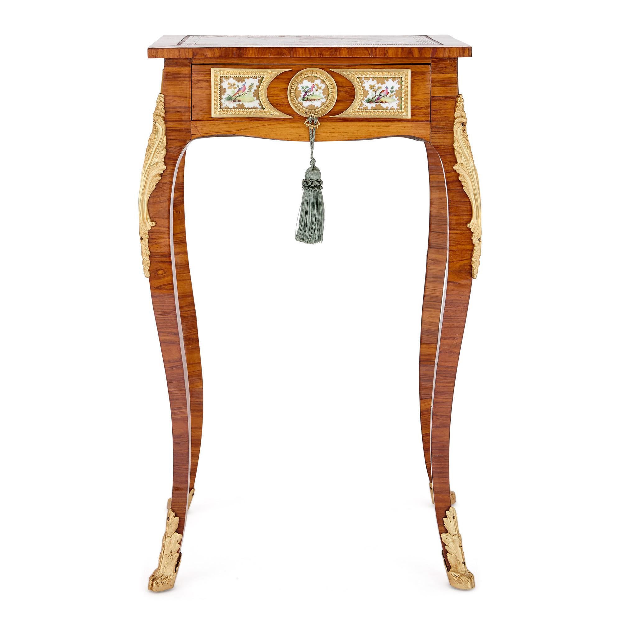 This beautiful side table was designed in France in the 19th century in the fashionable Rococo, or Louis XV, style. The piece has been crafted from kingwood and decorated with painted porcelain plaques and ornamental gilt bronze mounts. 

The
