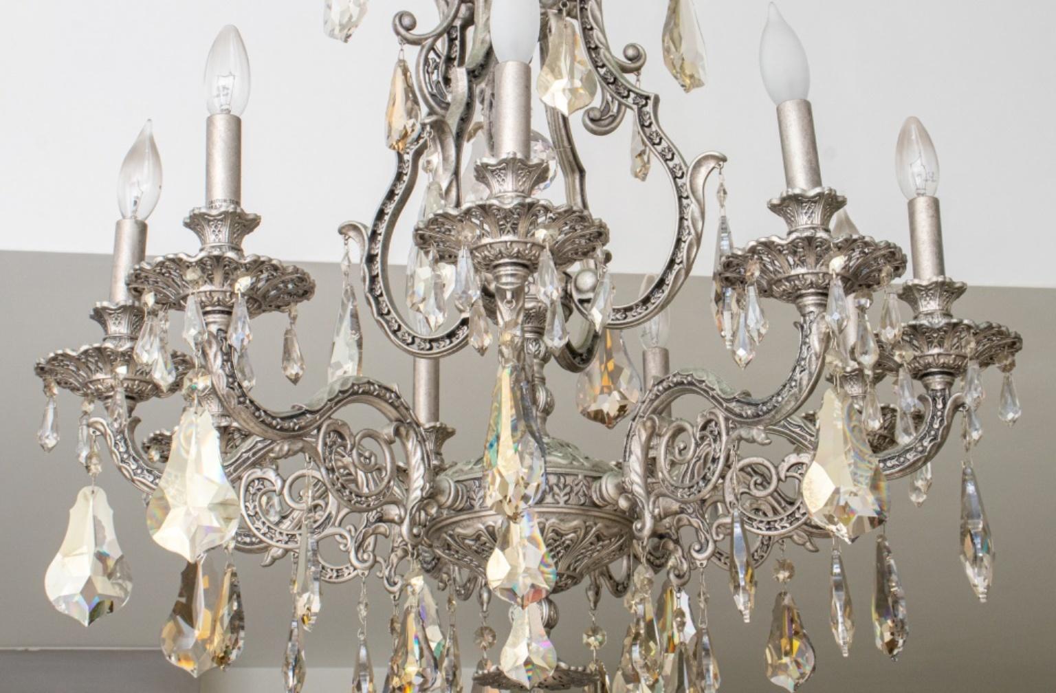 French Rococo Revival crystal chandelier with chased silvered metal frame, eight arms topped with faux candles, with dangling cut glass crystals. In good condition. Wear consistent with age and use. Hardwired.
Dimensions: 30