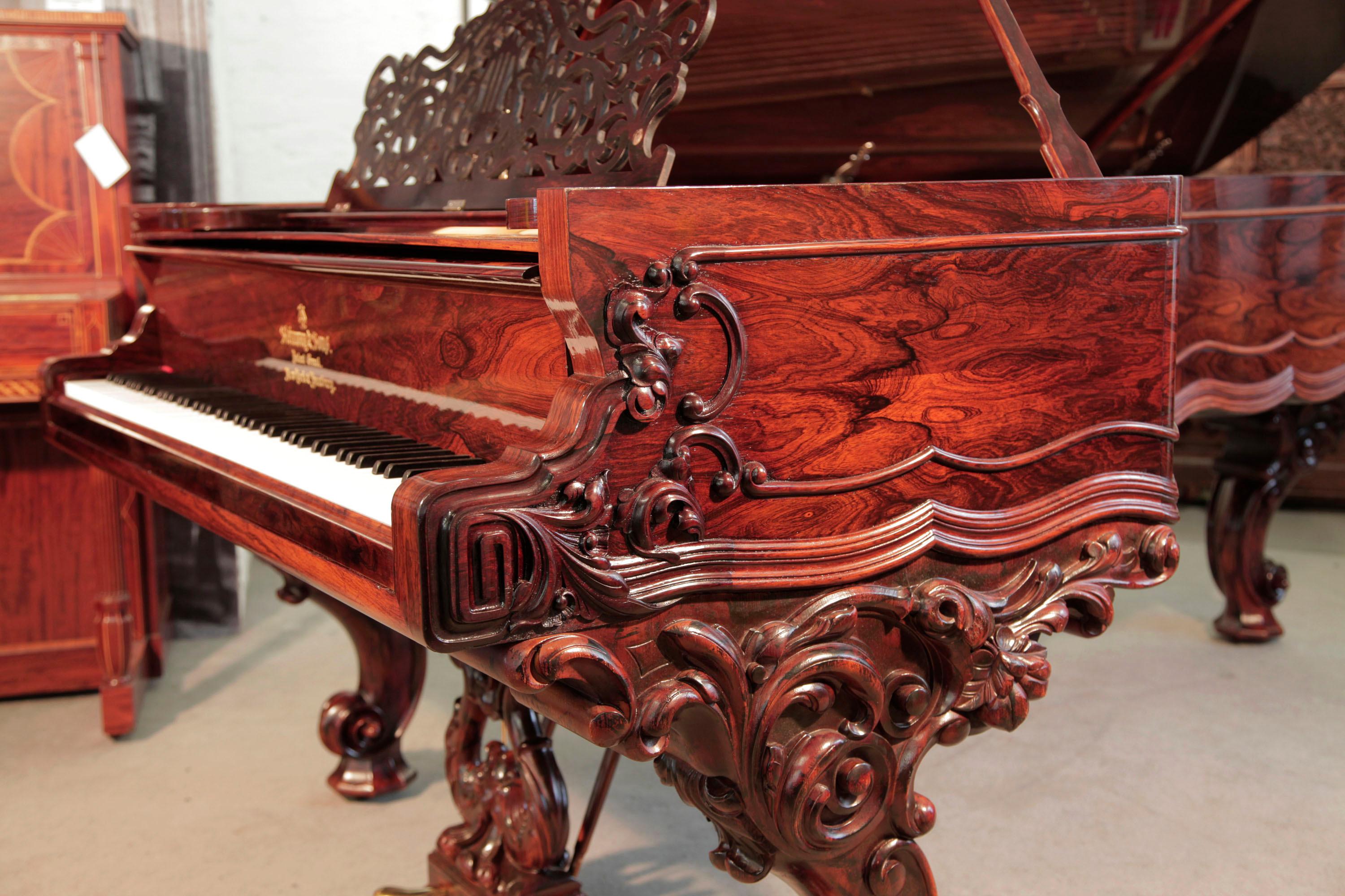 Rococo style, 1874, Steinway & Sons Centennial concert grand piano with a rosewood case, filigree music desk and ornately carved, reverse scroll legs. Piano is rebuilt.

The piano cheek features a carved, Classical meander and acanthus in high