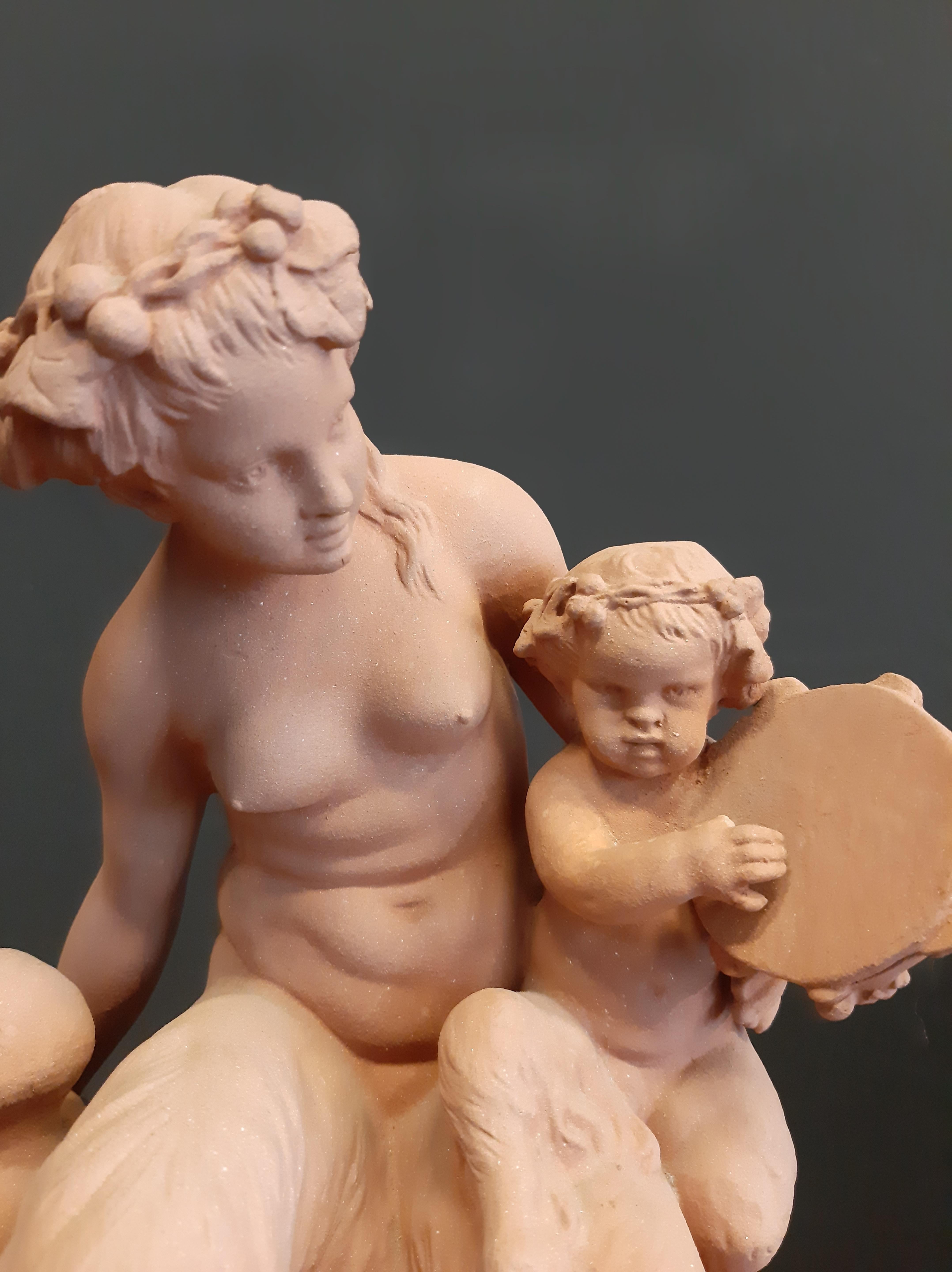 Scultura in terracotta proveniente da Clodion France, raffigurante un Fauno femmina seduto con bambini fauni al suo fianco e un tamburello in mano...

