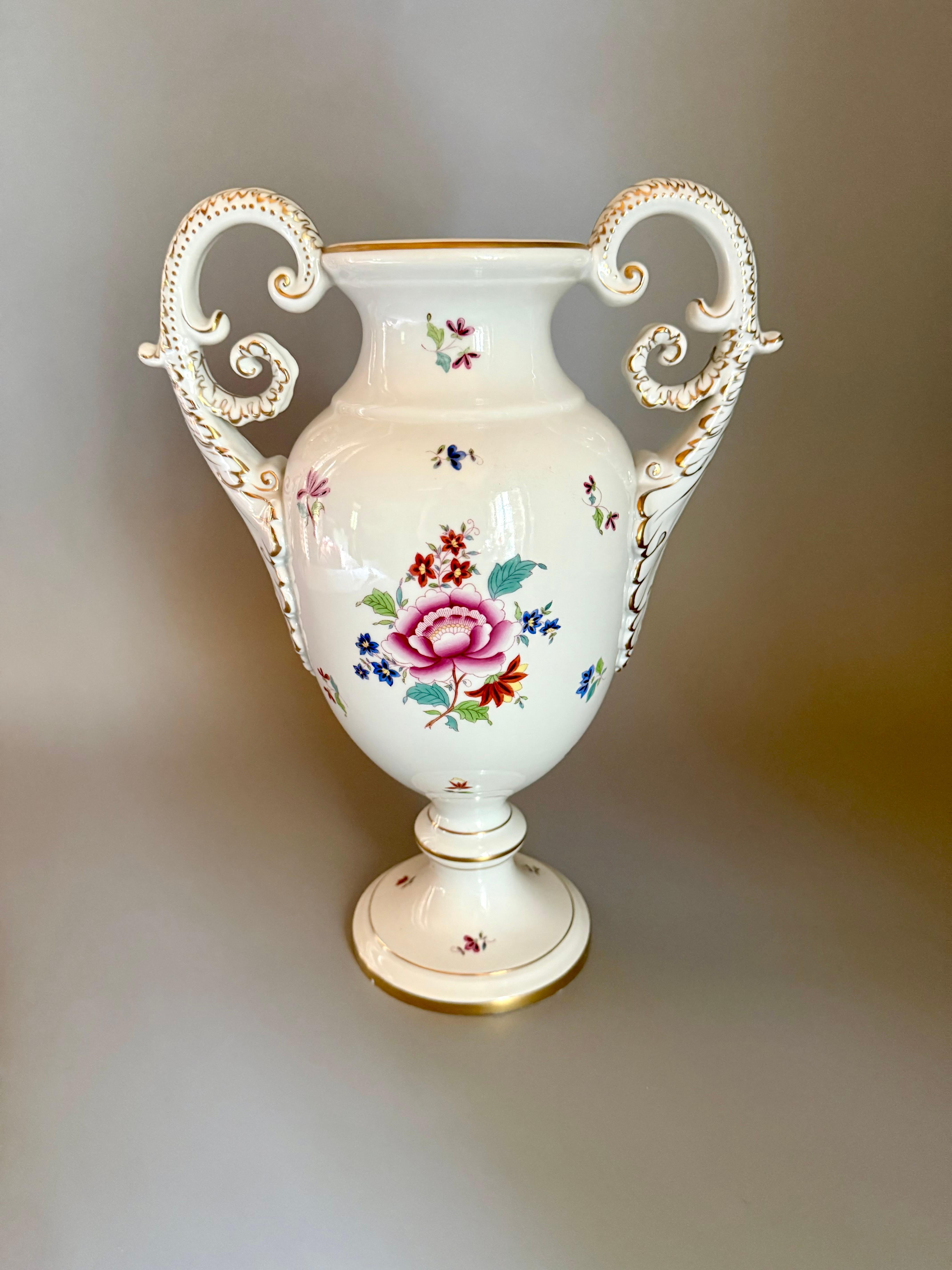 A Large Vintage Vase Herend Hungary
1950-1960 according to a mark 
Delicately hand-painted wit various beautiful flowers 
2 handles have Baroque style shape and richly gilded 
Height 34 cm (13,4 inches)
Lowest gold ring on the strand has very small