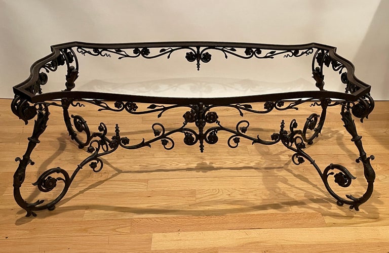 Wrought iron coffee table, 19th century Italian in the Rococo style. Most likely from Florence, this hand wrought beauty has an inset glass top to reveal the substantial but delicate cross supports.