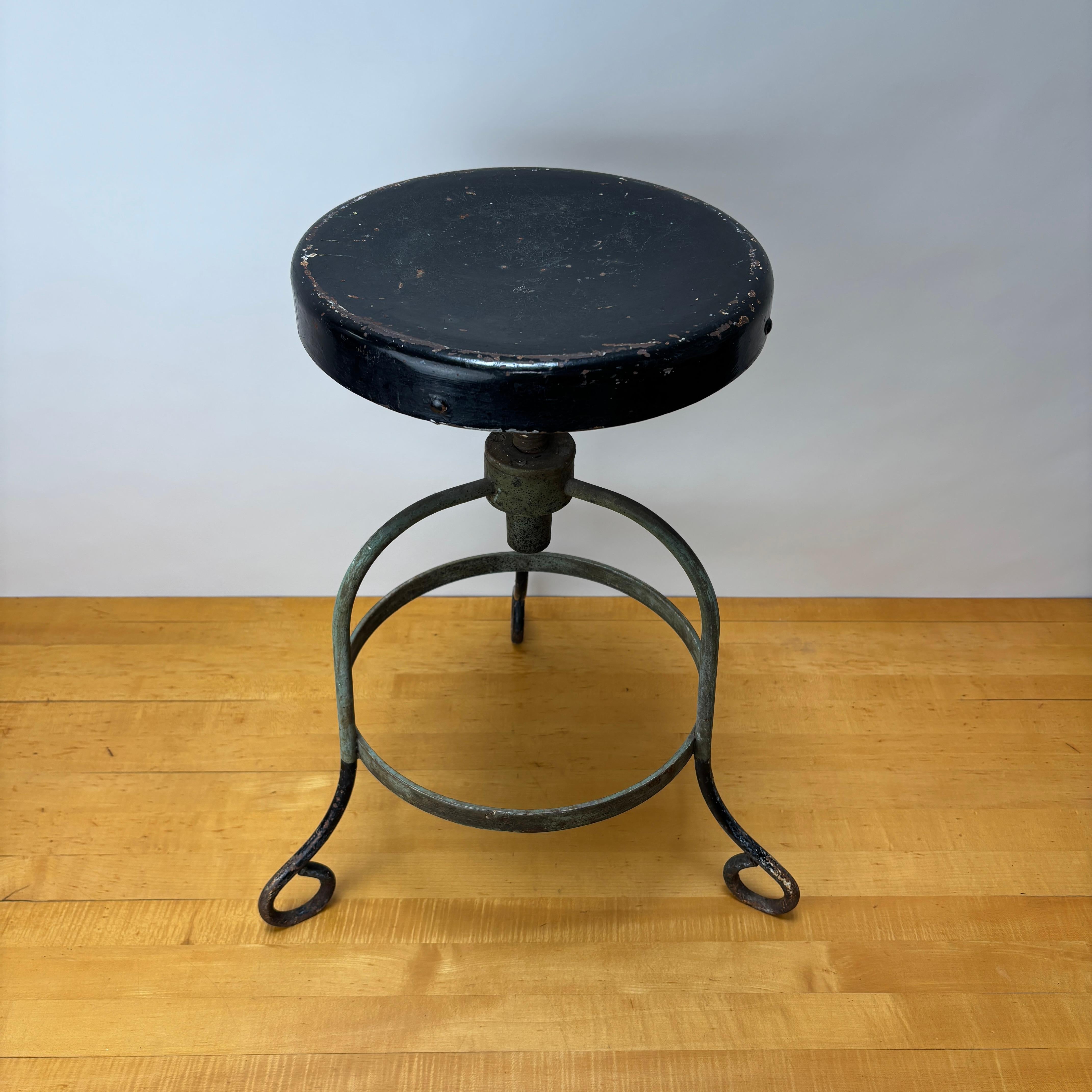 Tabouret antique à hauteur réglable.

Ce tabouret présente des détails très forts et très simples, à commencer par les pieds recourbés qui reviennent vers l'intérieur, suivis du collier riveté.  et ensuite le siège avec fixation en fonte et hauteur