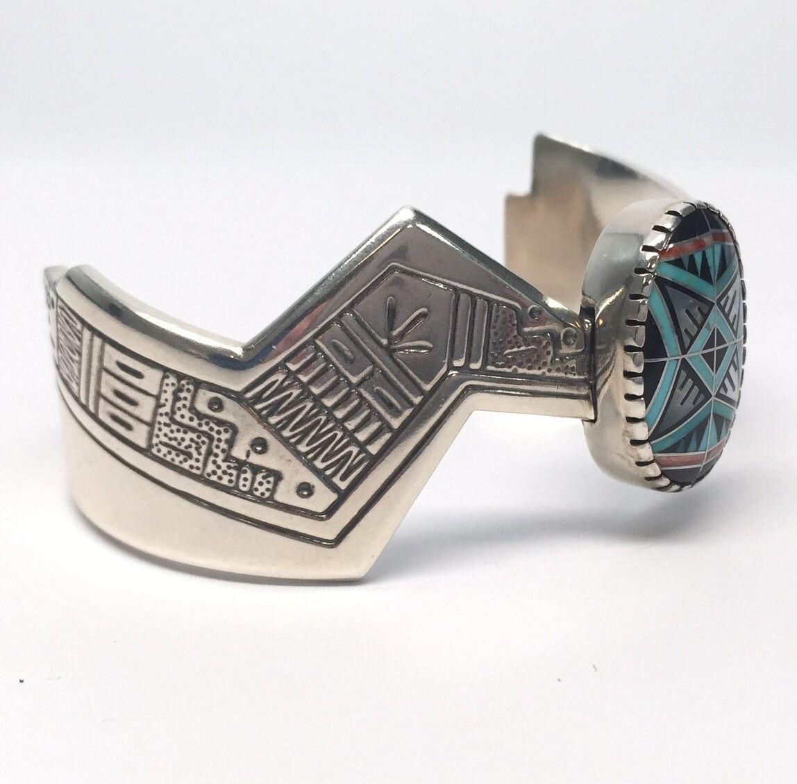 Roderick Tenorio Relios sterling silver multi-stone inlay Morning Star cuff bracelet. Stones include turquoise, onyx, coral, and mother of pearl.

Marking: Relios hallmark, .925, ©, RMT, Sterling.

Measures approx. 5 1/8