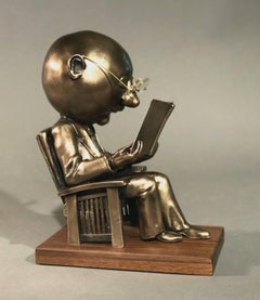 The Reader (small), gold bronze sculpture, reading book, glasses, Rodger Jacobsen