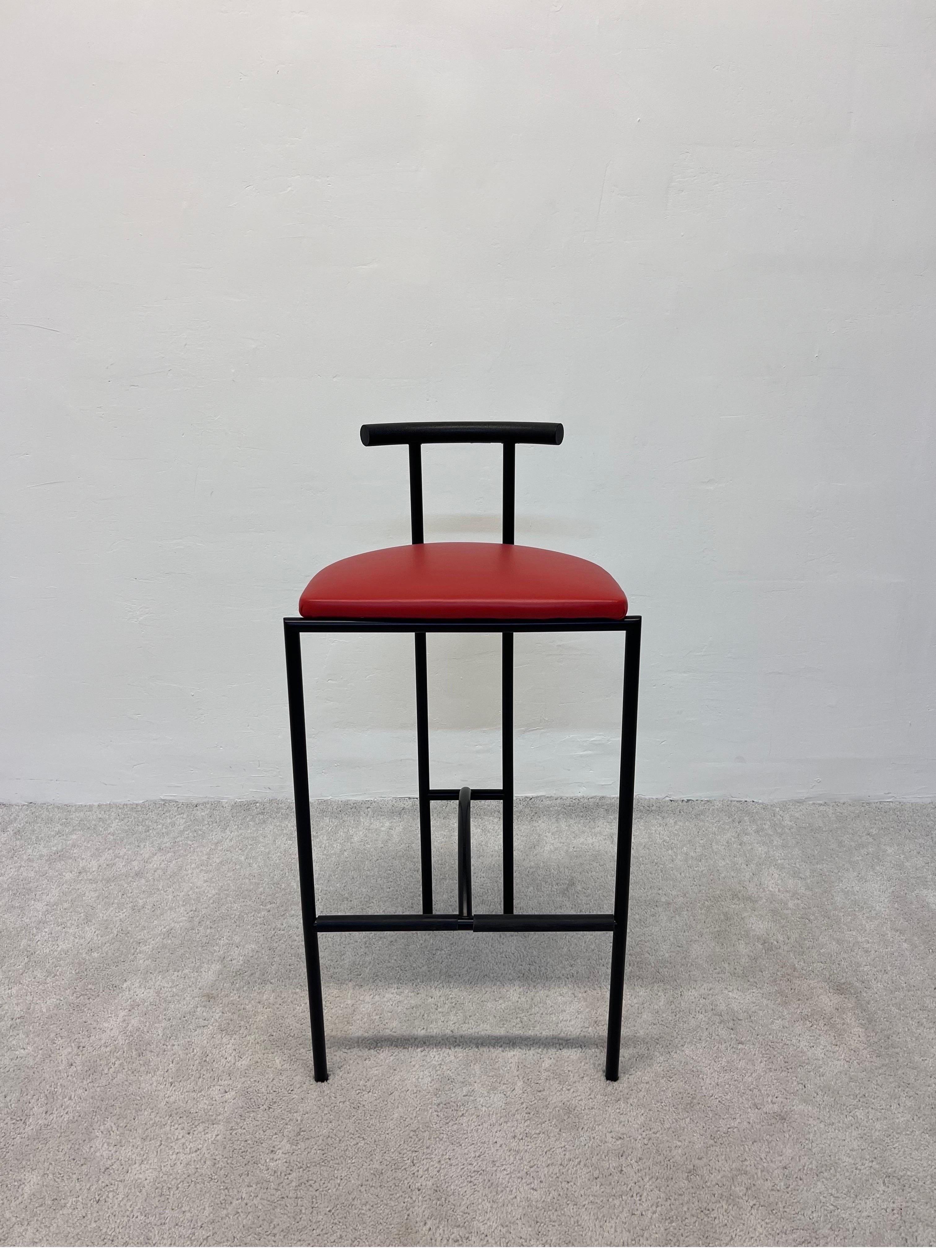 Postmodern Tokyo counter stool made of a satin black steel frame, curved black polyurethane backrest and a red naugahyde cushioned seat. The footrest maintains the plastic tube protectors. Designed by Rodney Kinsman circa 1980s and manufactured by