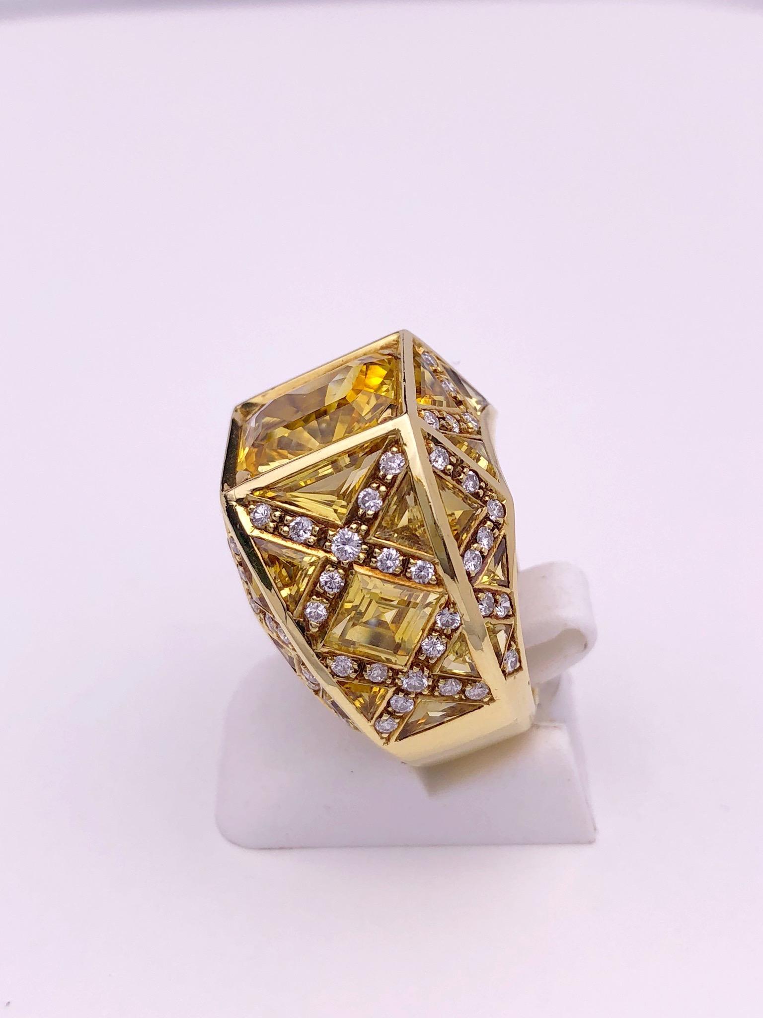 Rodney Rayner is well known for his unique style. This ring is the perfect example. Crafted entirely in 18KT yellow gold the highlight of this ring is the magnificent 5.23 carat Emerald cut Yellow Sapphire. Triangle and Lozenge cut Yellow Sapphires