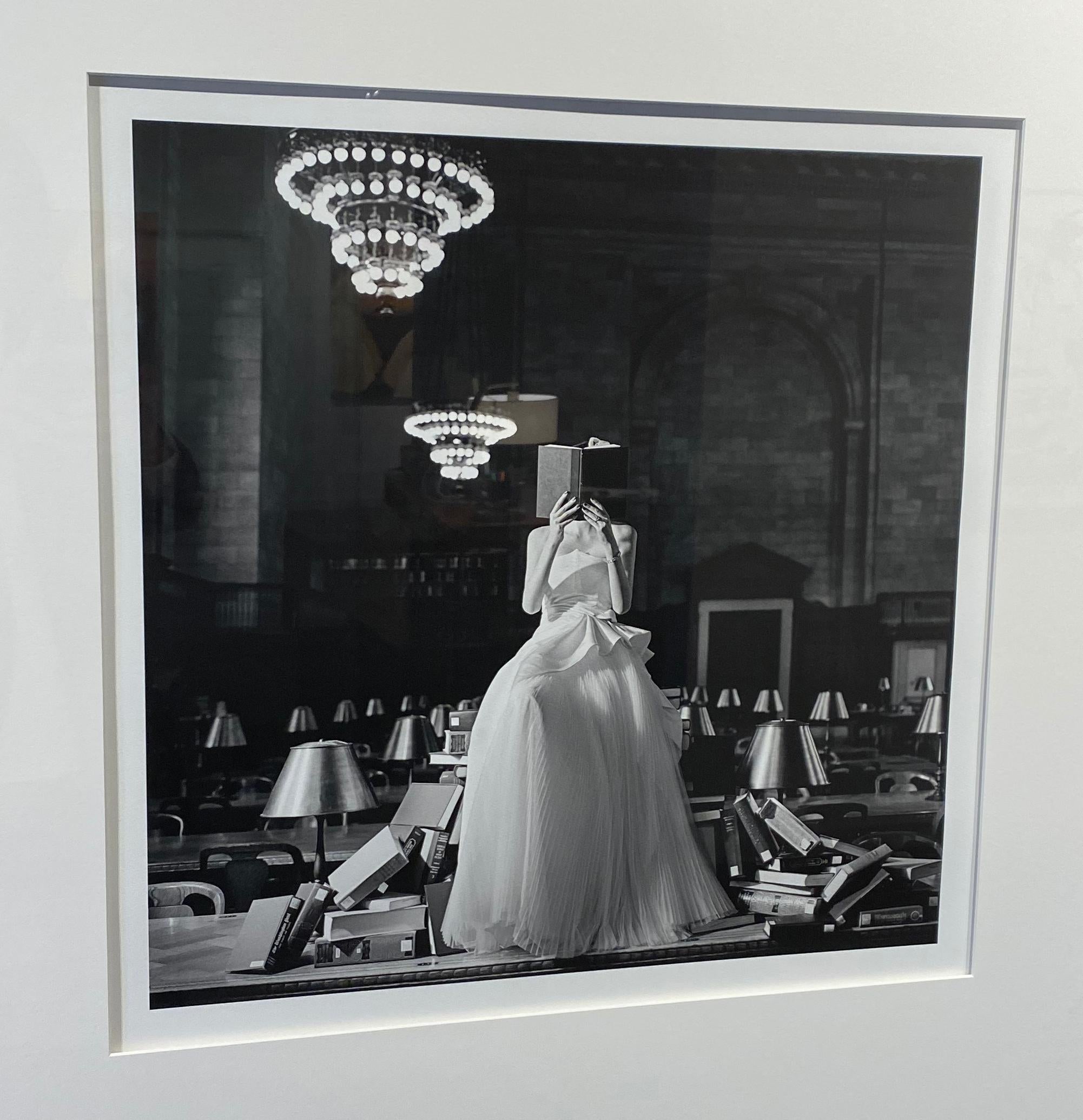 Black and white estate photograph featuring a female figure reading in the New York Public Library, framed in black by Rodney Smith. 
Each image is part of an edition of 25. Price increases as the edition sells out. His work is available in three