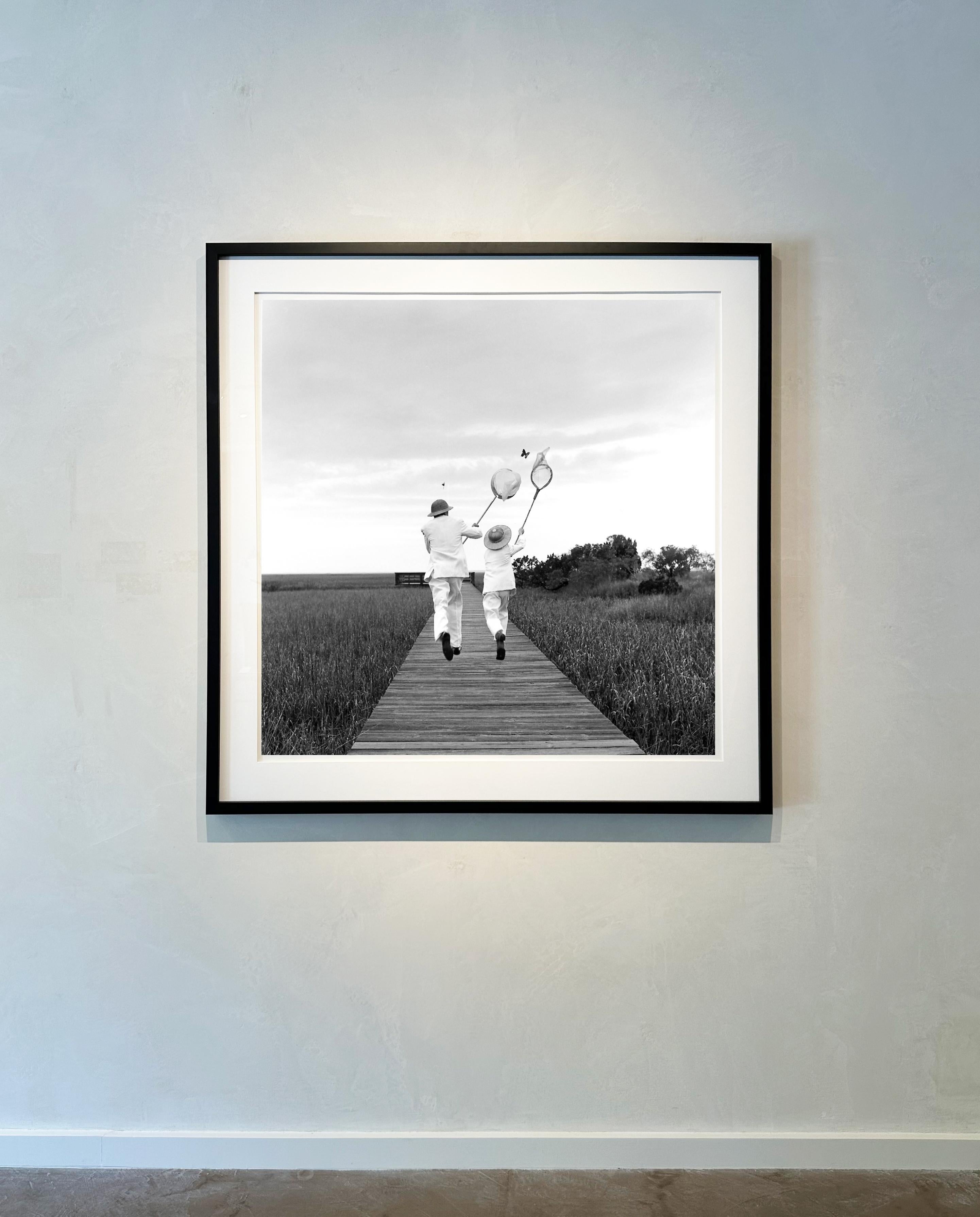Gary and Henry chasing butterfly, Beaufort, SC - 50 x 50 inches, Framed - Photograph by Rodney Smith