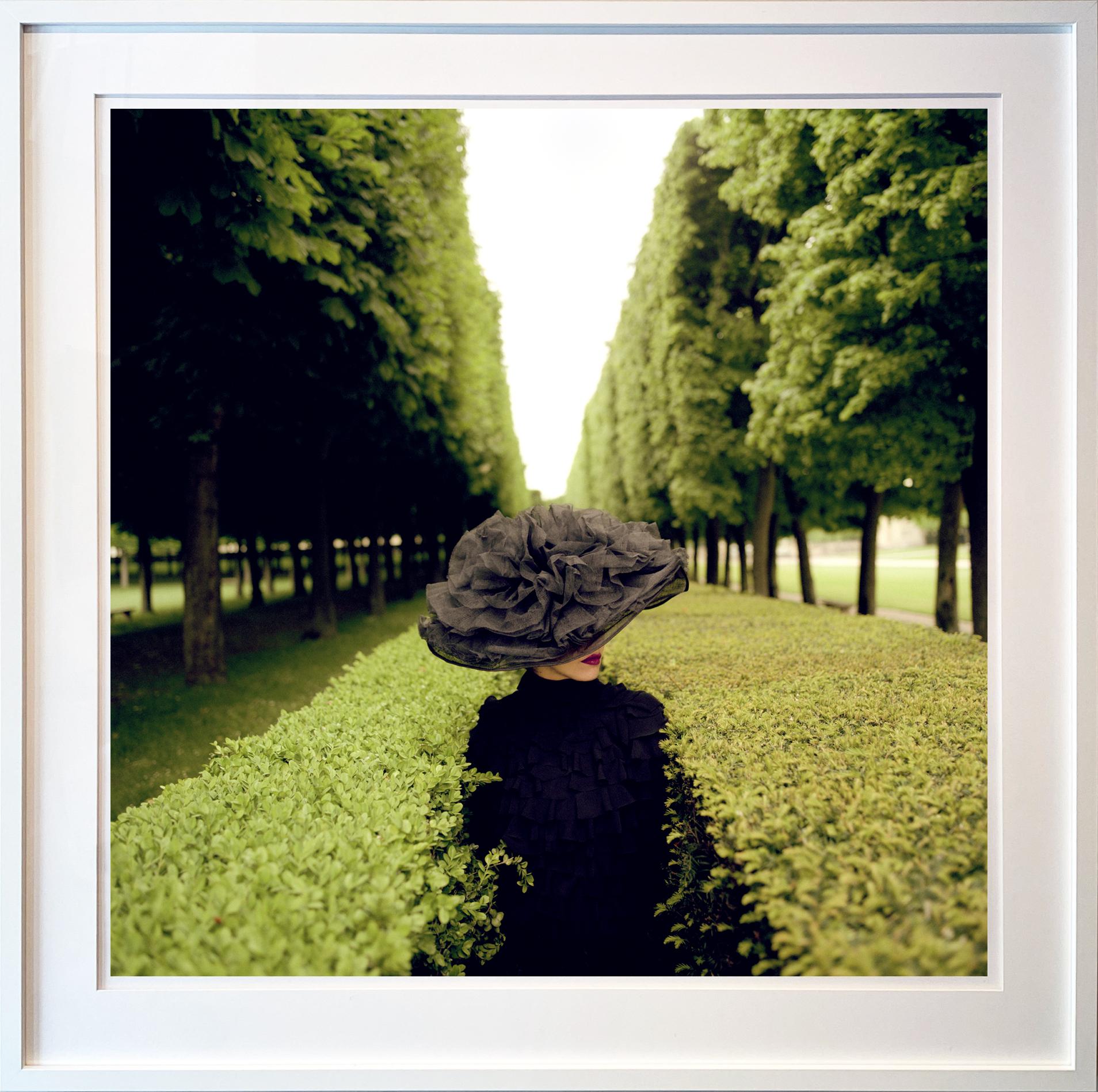 Woman with Hat Between Hedges, Parc de Sceaux, France - 50 x 50 inches framed - Photograph by Rodney Smith