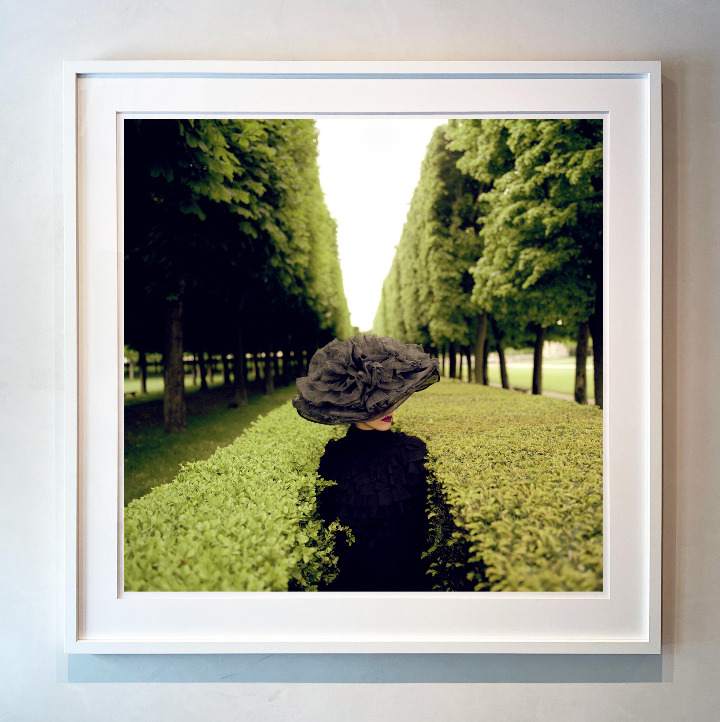 Woman with Hat Between Hedges, Parc de Sceaux, France - 50 x 50 inches framed - Contemporary Photograph by Rodney Smith