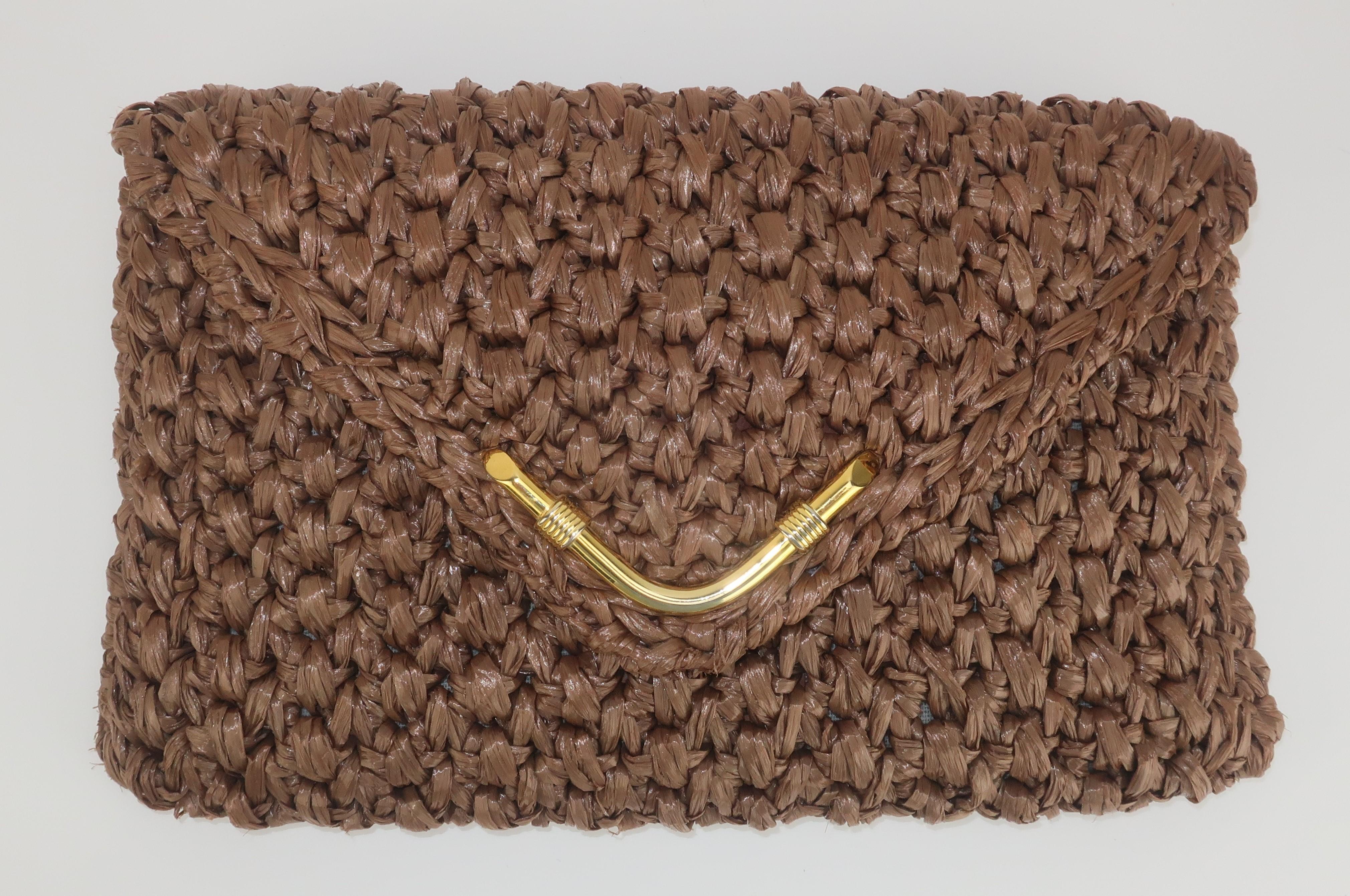 C.1970 Rodo Italian envelope style handbag fabricated from a light taupe brown raffia woven to perfection.  The snap front closure is embellished with a gold tone metal accent and it opens to reveal a roomy interior lined in two tone brown leather.