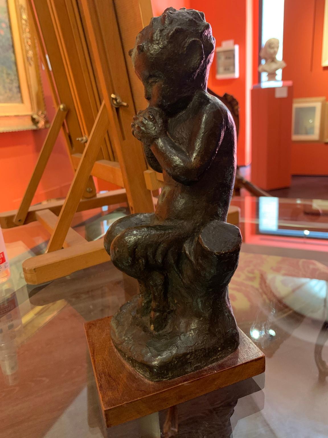The small bronze depicts a small seated faun, immortalized while playing a wind instrument as can be clearly seen by the puffy cheeks. is signed at the base R. Castagnino and is from a ceramic prototype modeled in a manufactory in Albissola,