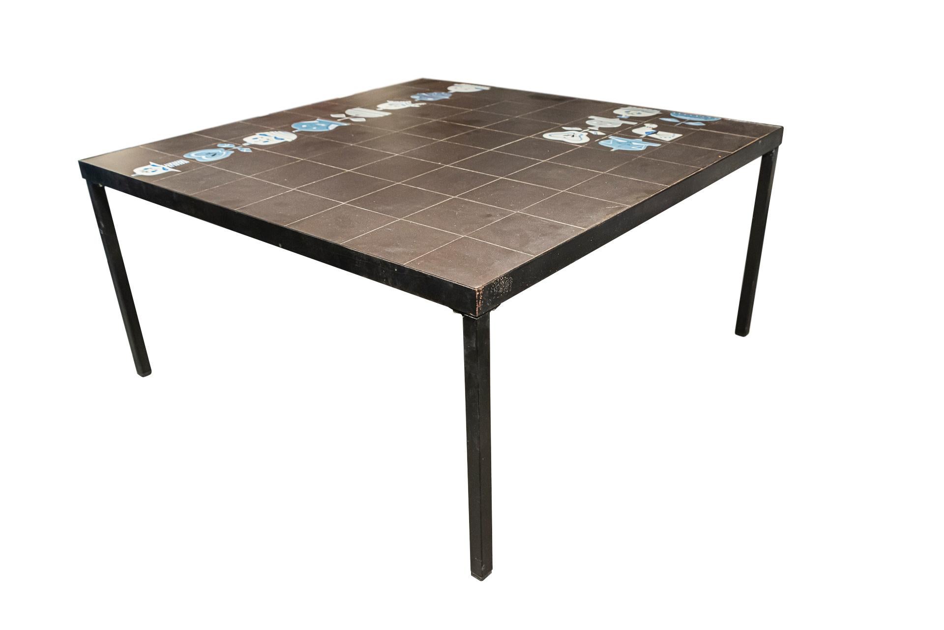 Square coffee table, 
Matte ceramic, black or colored enameled tiles possibly Roger Capron, metal lacquered foot,
Remade bottom, no signature,
France, circa 1970.

Measures: Width 80.6 cm, depth 80.6 cm, height 39.4 cm.

Roger Capron, born in